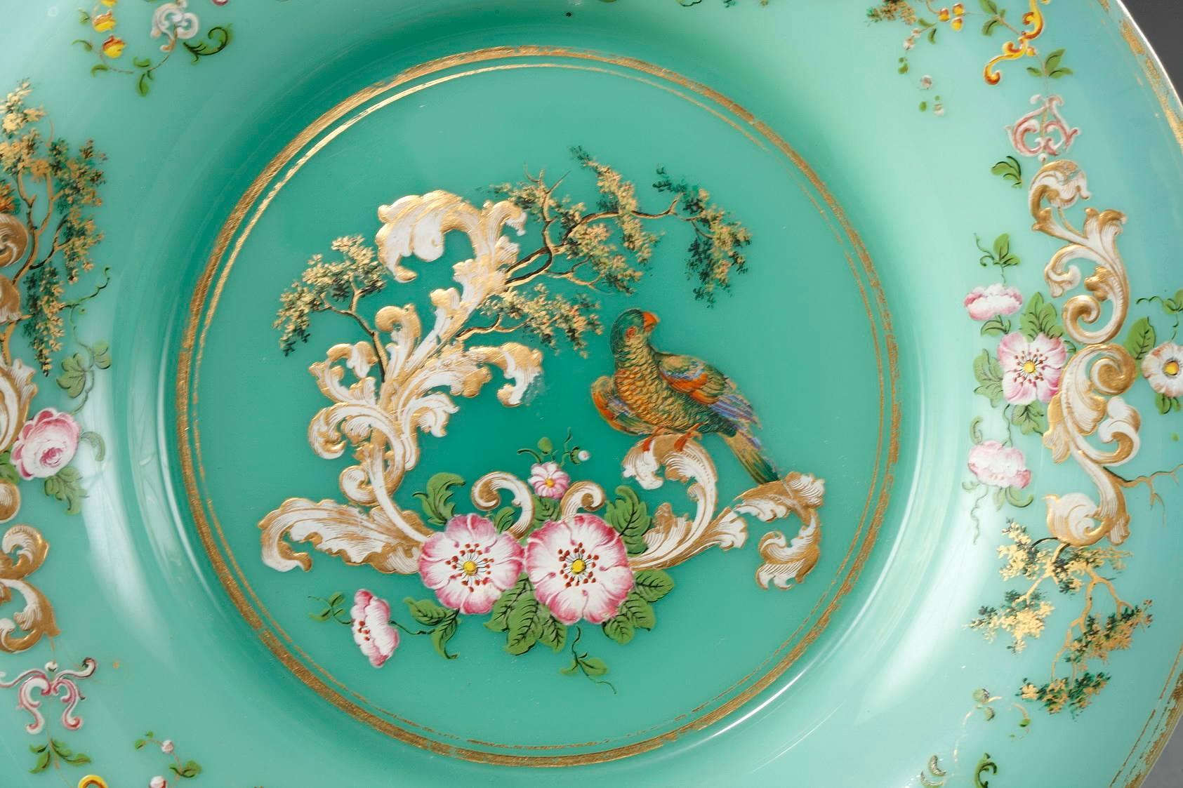 Set of six, green opaline crystal plates decorated with naturalistic flowers, rinceau, branches and parrots. The rim and center of the plate are embellished with a band of gilding. This plate was designed in the taste of Jean-François Robert. Light