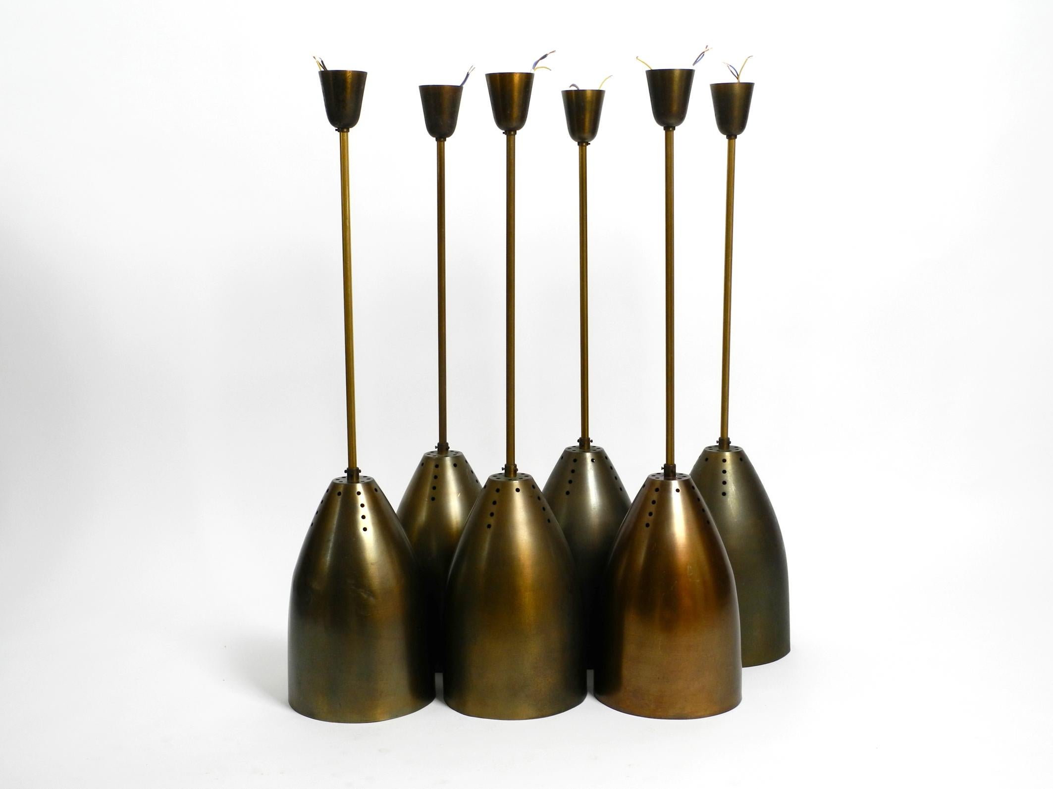 Six very nice and rare large original mid century brass pendant lamps.
These lamps hung in a German church for over half a century.
Large shade, rod, canopy and socket are made of brass.
With three locking screws to the rod at the top of the shade