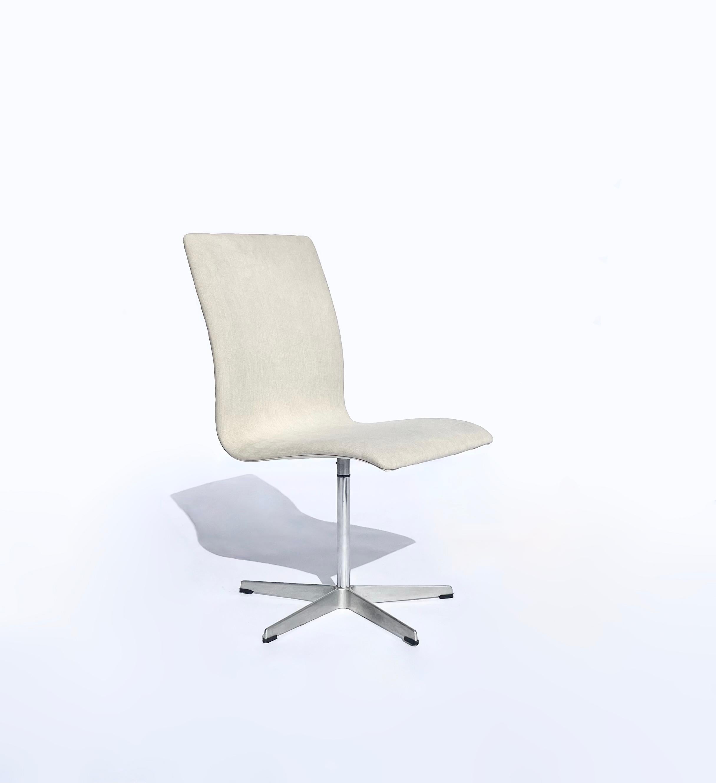 Six vintage swiveling, fixed-height, armless “Oxford” chairs with newly reupholstered seats in the cream colored fabric shown. Each chair has its original Fritz Hansen label on the aluminum base, and all bases are in great vintage condition. 