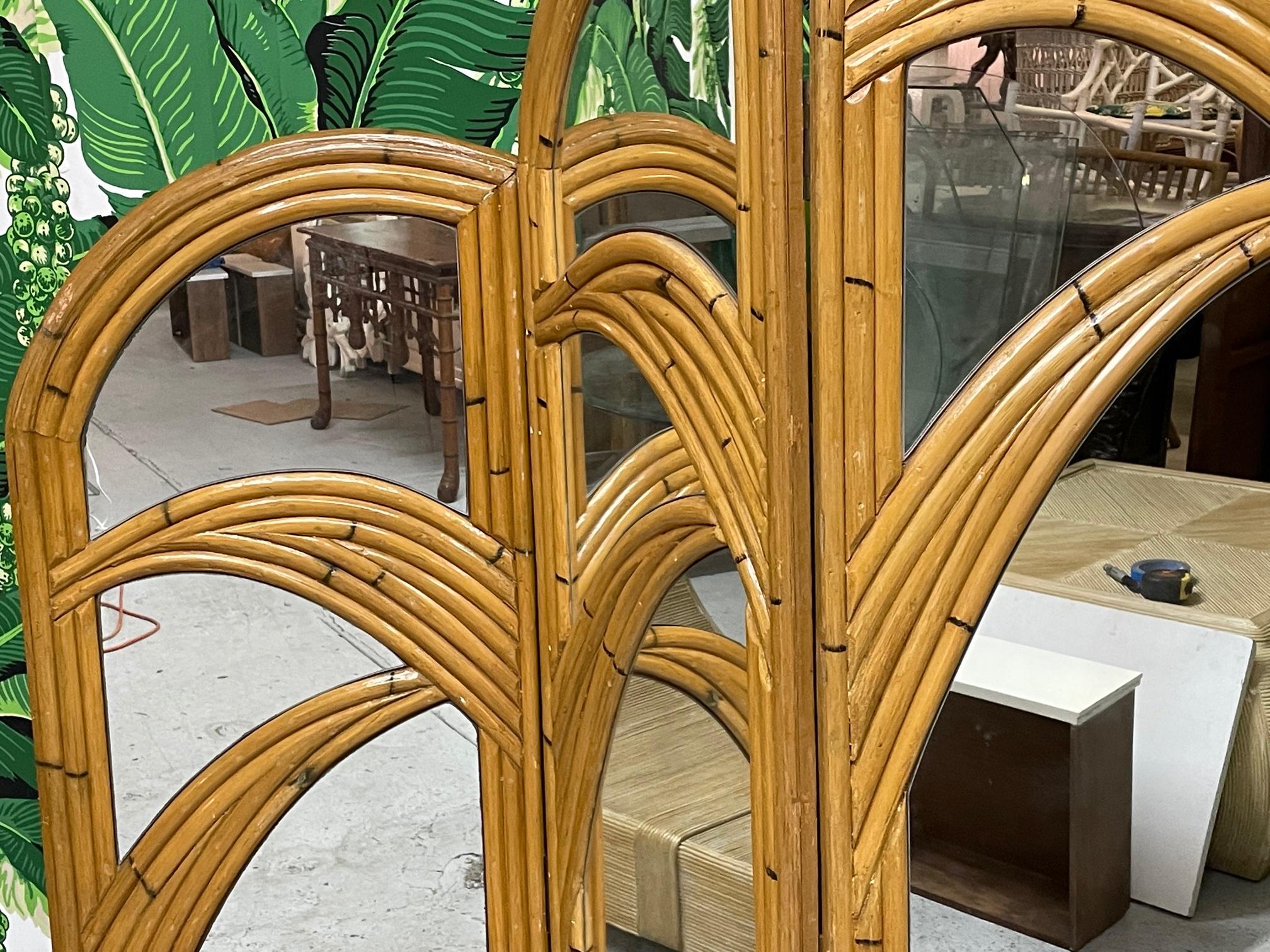 Pair of 3-panel room divider screens feature veneer of pencil reed rattan in a palm tree motif. Very good vintage condition with only minor imperfections consistent with age. Left screen is slightly lighter in color than right screen. Each panel