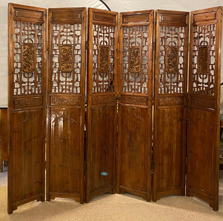 Six-panel teak, Asian, early 20th century. Folding screen / room divider. This spectacular one of a kind six panel work of art depicts Chinese glamour at its peak. The finest carvings abound in the manner of love birds perched onto tree bark and