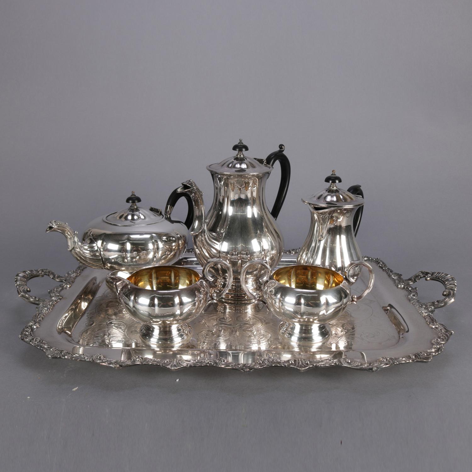 Marlboro silver plate Old English reproduction six-piece tea set features Mellon form and footed with ebonized wood insulated handles and includes coffee and tea pots, open sugar with gold wash interior, and scrolled incised double handle serving