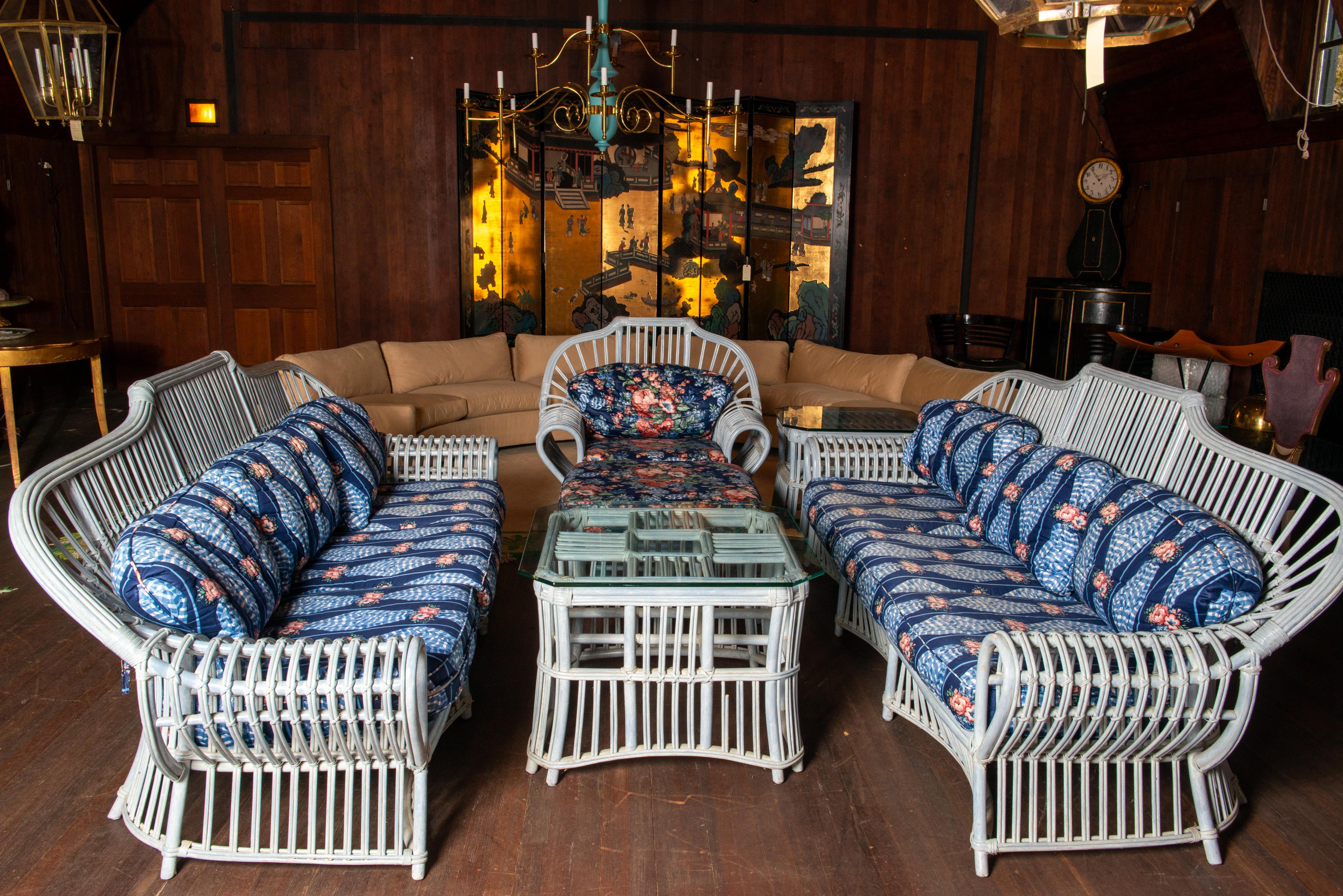 A spectacular pair of Ficks Reed rattan sofas in an original factory finish: a pale blue wash. Original cushions to use or for reupholstery. All cushions and rattan pieces are in great condition. 
Included are an arm chair with ottoman, a glass top