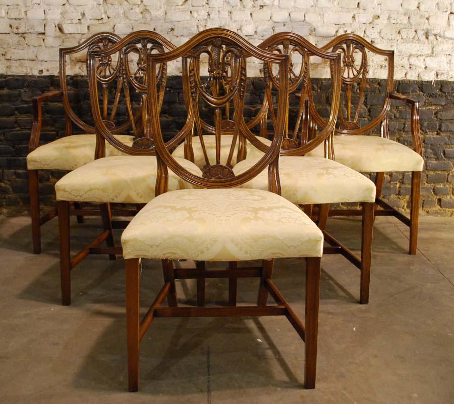 Beautiful set of George III hand carved mahogany dining chairs in the manner of George Hepplewhite.
The chairs all have a shield-shaped lyre back with wheat ear decoration, square tapering legs, and cross stretchers.
The solid hand carved mahogany