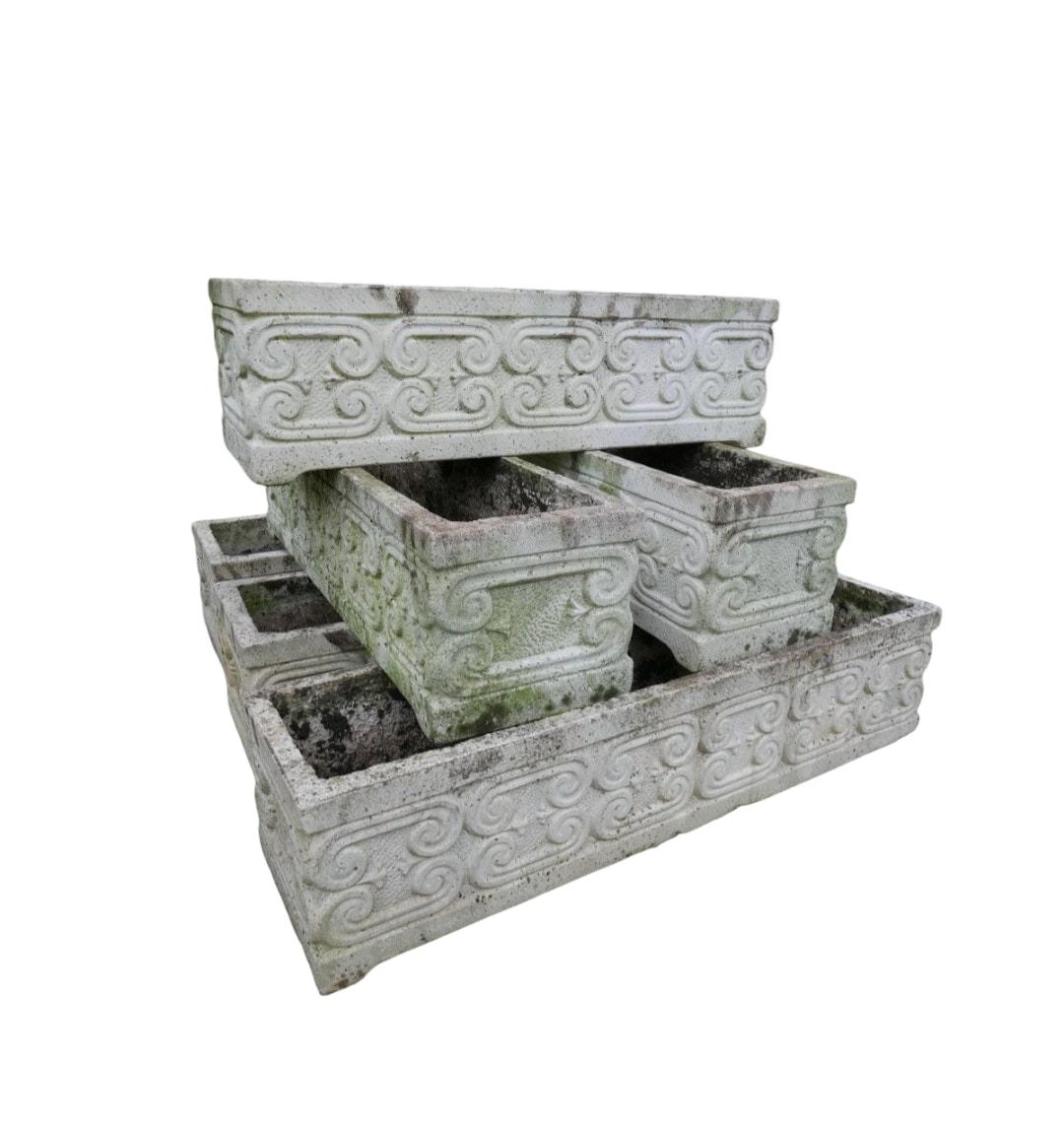 Transform your garden or patio with this exquisite Set of Six Reconstituted Stone Planters. Featuring intricate scrollwork and stylized fleur-de-lis decorations, these planters from the mid-20th century offer both elegance and functionality, perfect