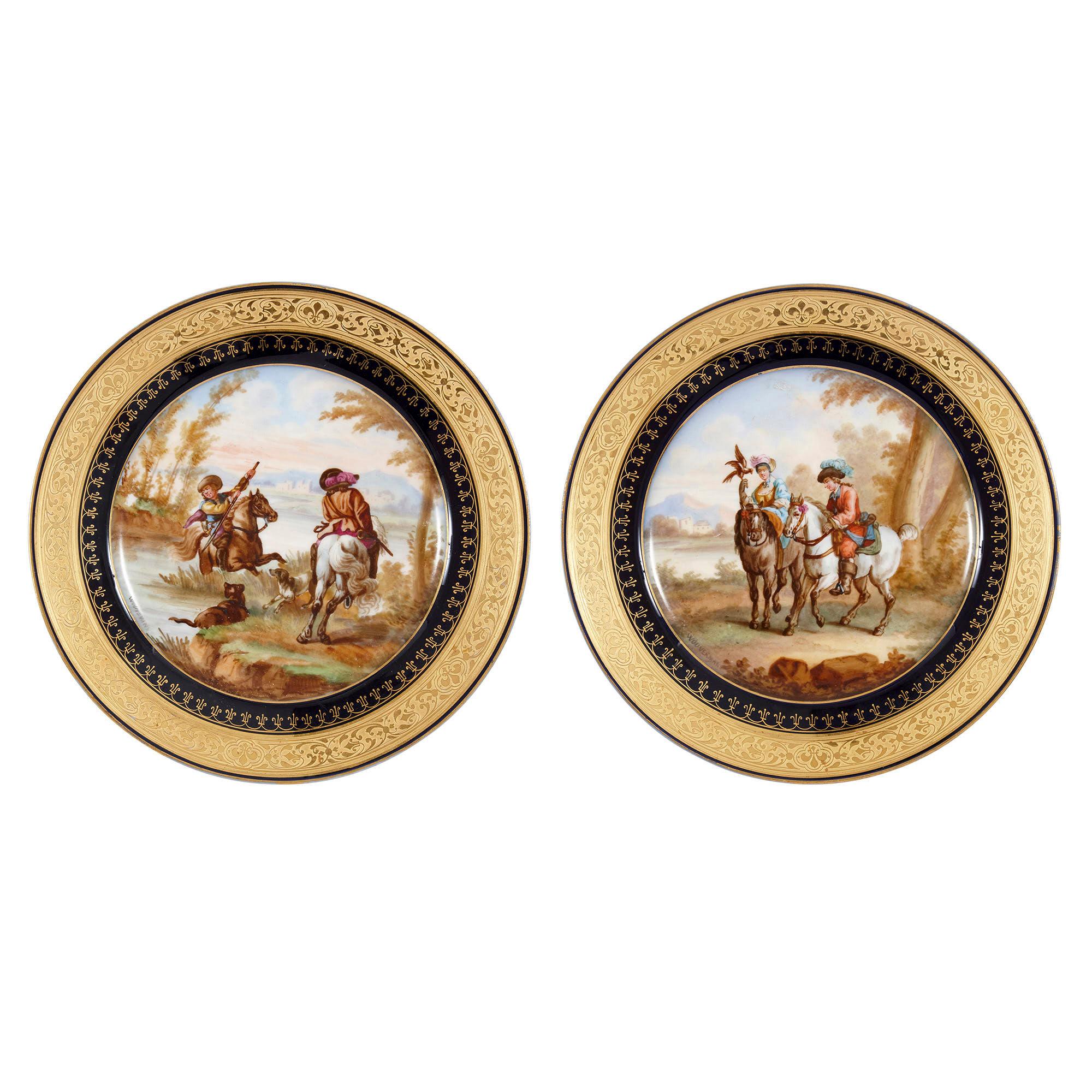 Chaque assiette en porcelaine de ce lot de six présente un fond bleu marine, caractéristique des œuvres produites dans le style de Sèvres, et des bords dorés avec des motifs ornés inscrits. Le centre de chaque plaque est peint d'une représentation