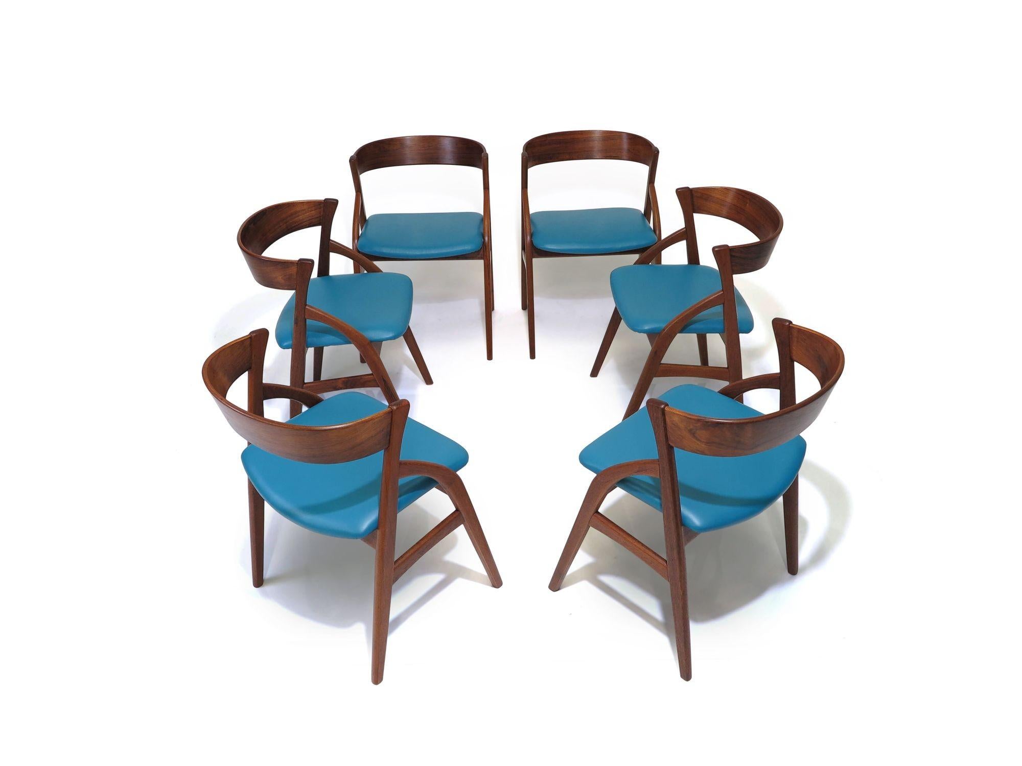 Ensemble de six chaises de salle à manger en bois de rose danois du milieu du siècle, fabriquées à la main avec des cadres arqués et un dossier incurvé spectaculaire. Cadres parfaitement restaurés et nouvellement recouverts de cuir bleu. Les