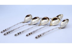 Six Russian-style silver teaspoons with wreath motifs and spiral handles