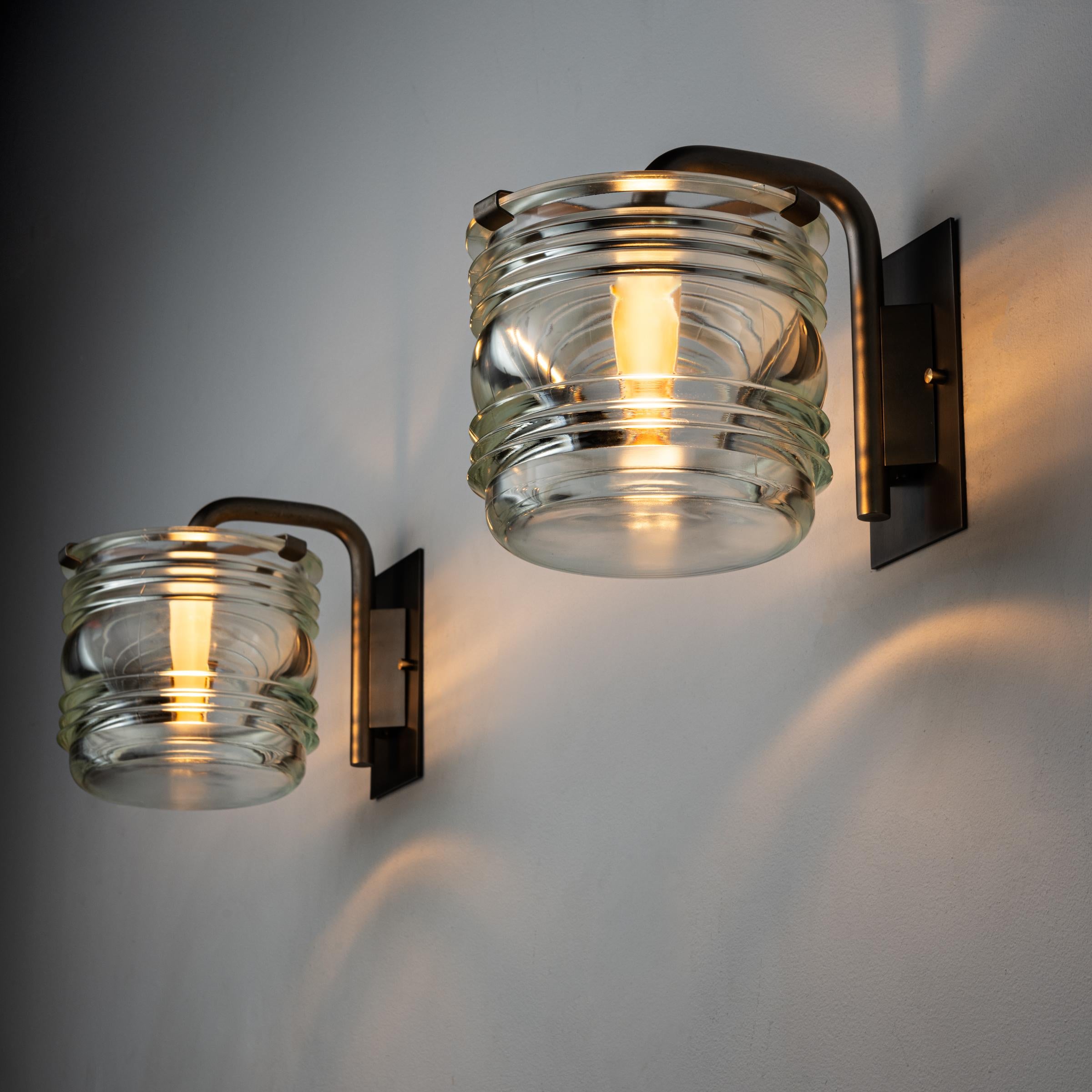 Four Sconces by Candle. Designed and manufactured in Italy, circa 1950's. Glass, brass Wired for U.S. standards. Custom brass backplates. Lamping: Allow 1 qty 120v E27 Socket with 75w Frosted bulb. Light bulbs not included. PRICED AND SOLD