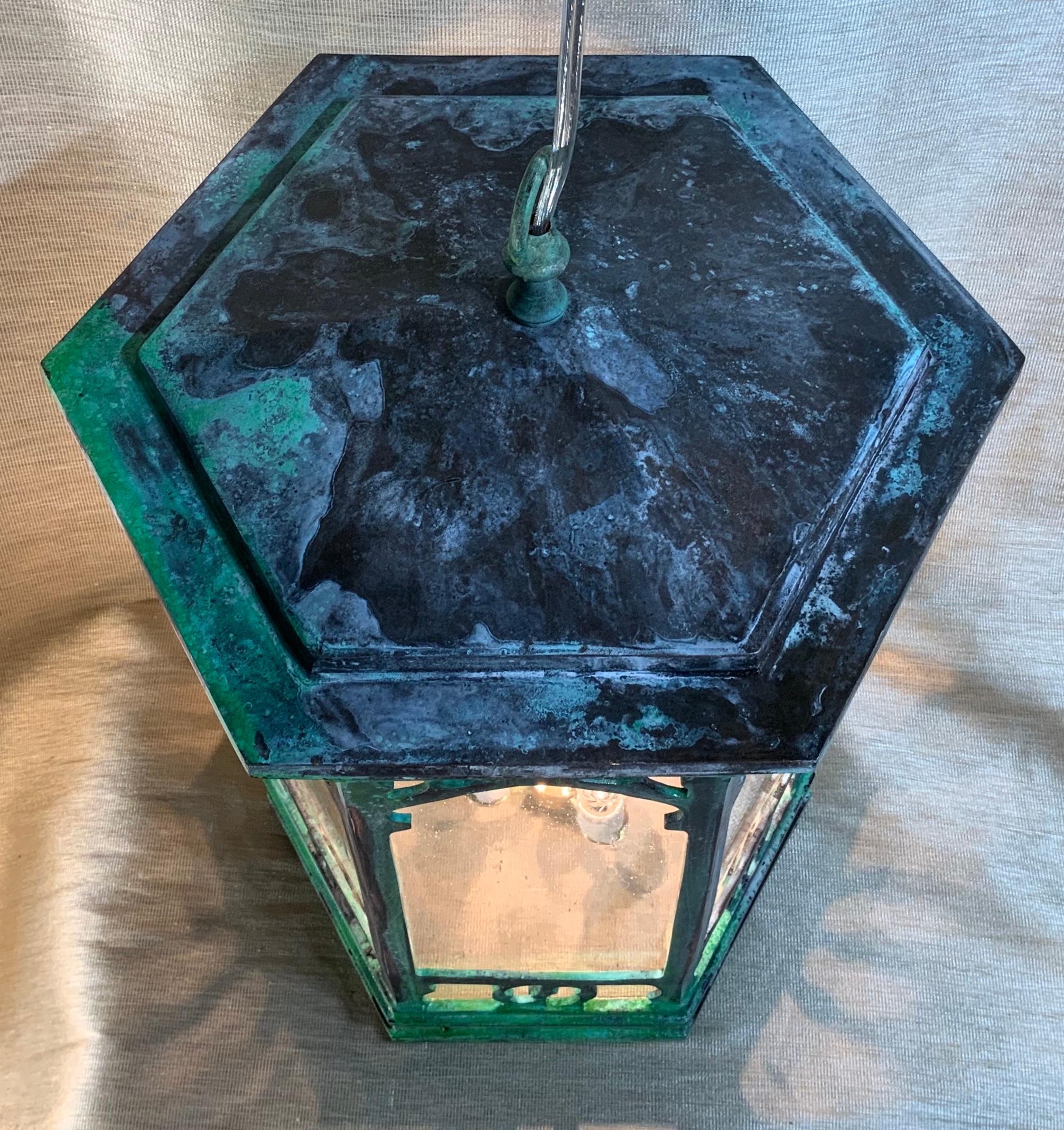 Elegant hanging lantern made of solid bronze with six sides seeded glass newly electrified with brass three 60/watt lights cluster. Brass canopy and chain included.
Could use indoor or outdoor.