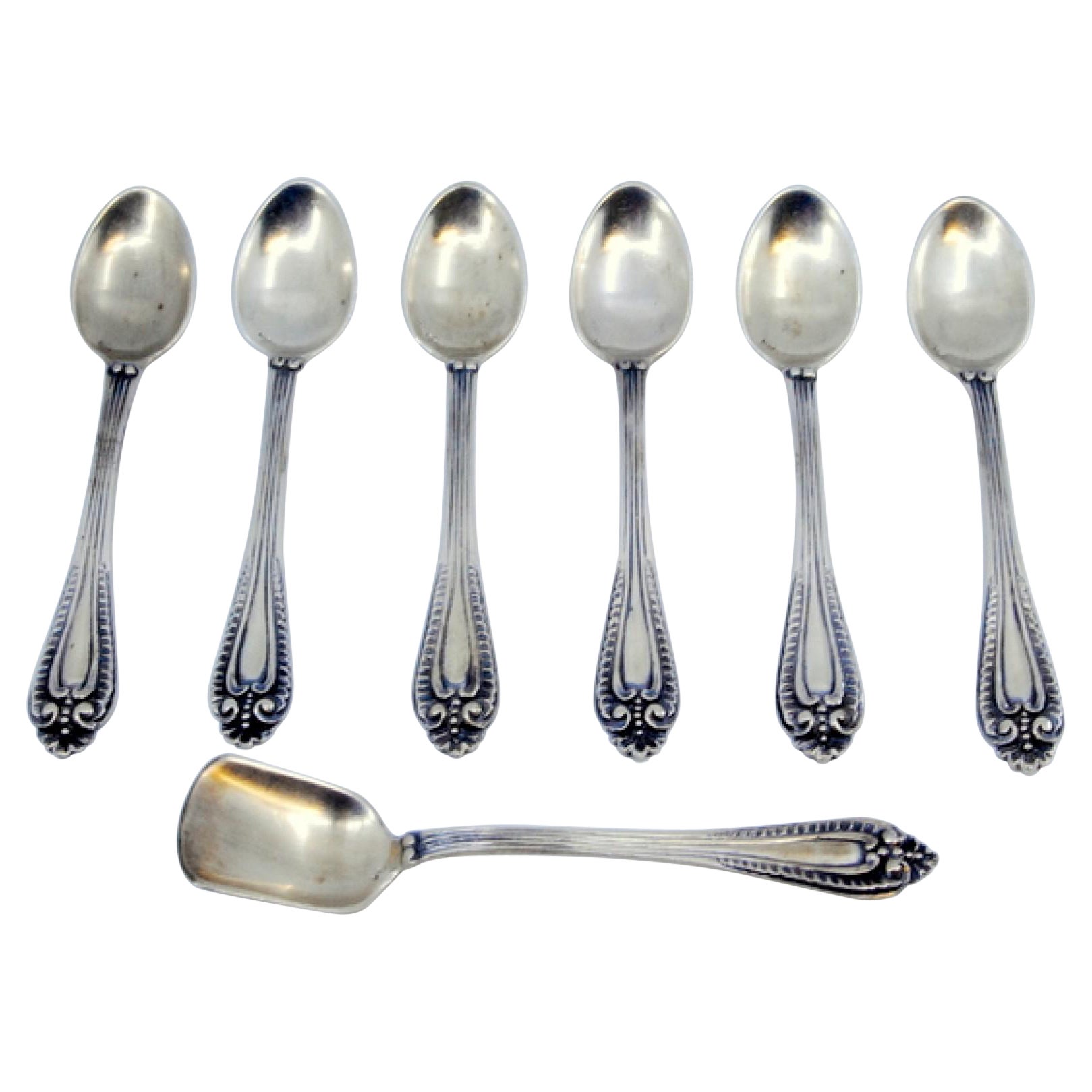 Six silver coffee spoons and sugar shovel with reliefs and grooved handles