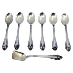 Six silver coffee spoons and sugar shovel with reliefs and grooved handles
