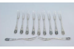 Six silver dessert forks with floral relief handles and monogram inserts