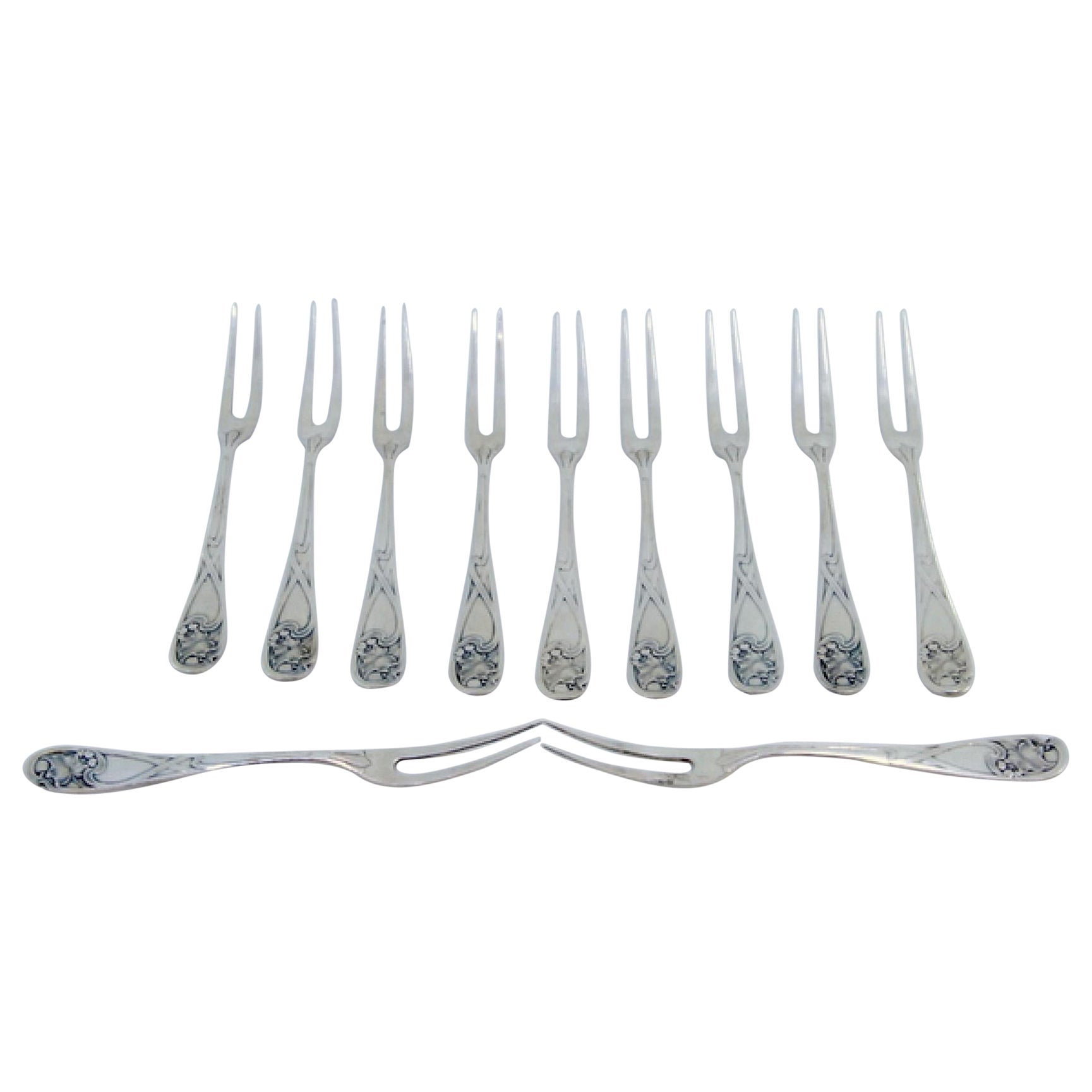 Six silver dessert forks with floral relief handles and monogram inserts