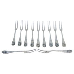 Six silver dessert forks with floral relief handles and monogram inserts