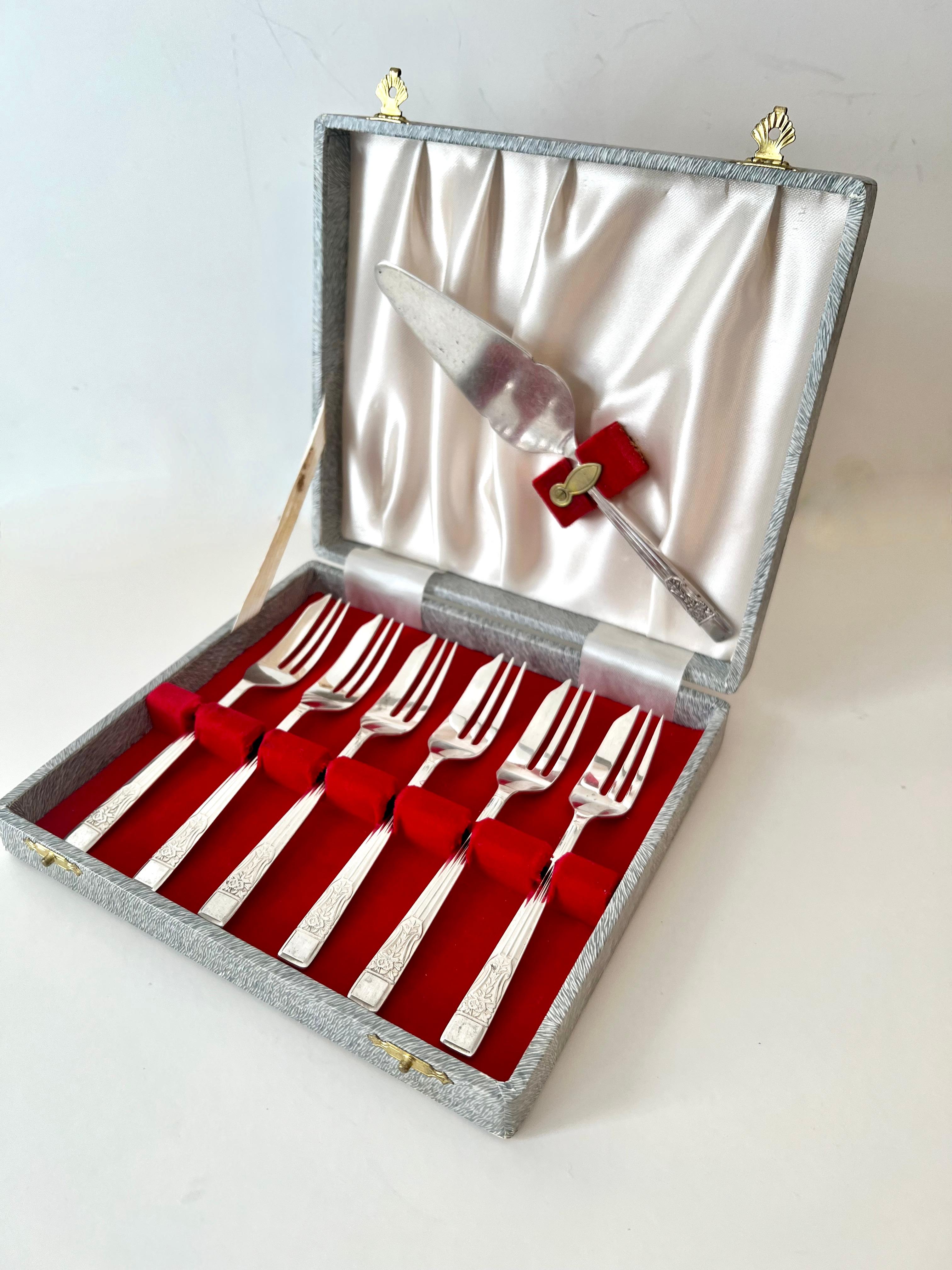 A lovely set of 6 Silver Plate Dessert Forks with coordinating silver plate serving piece.  

The set has a unique design and would be a compliment to any after dinner dessert to tea.  A bonus is they come in a box for easy storage and separation