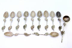 Six silver spoons and sugar shovel with raised handles and ribbed shell bowls