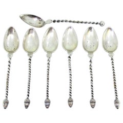 Six silver teaspoons and sugar scoop with twisted handles and acorn appliqués