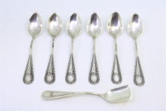 Six silver teaspoons and sugar shovel with reliefs and monogram handles