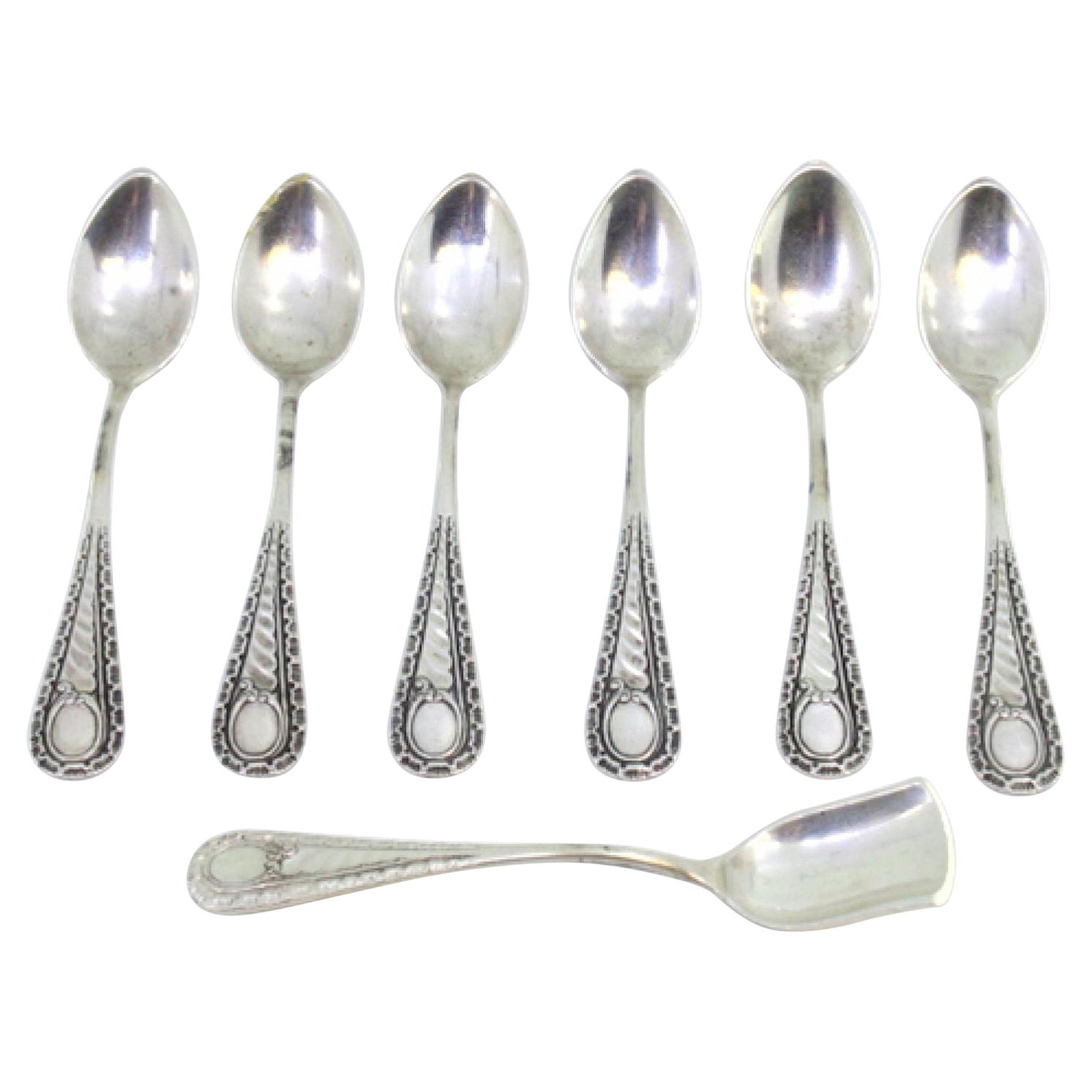 Six silver teaspoons and sugar shovel with reliefs and monogram handles