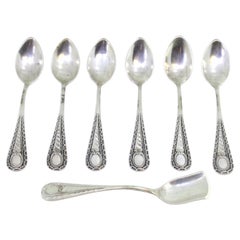Six silver teaspoons and sugar shovel with reliefs and monogram handles