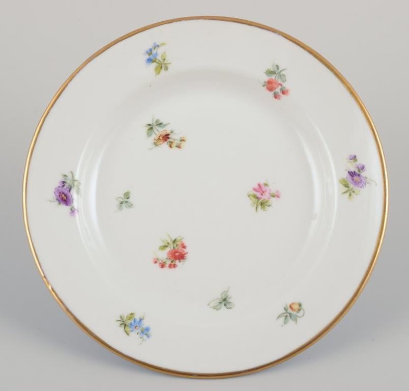 Seis pequeños platos de porcelana con motivos florales policromados y borde dorado. Glaseado en venta