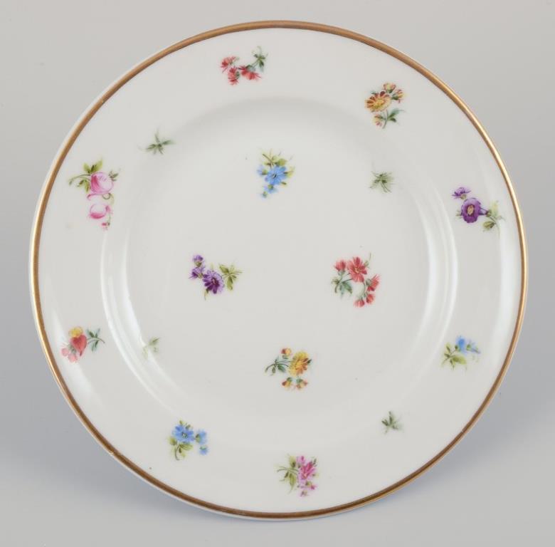 Seis pequeños platos de porcelana con motivos florales policromados y borde dorado. siglo XX en venta