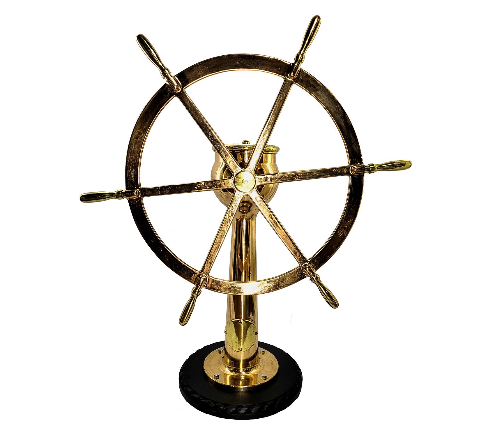 Highly polished ships wheel on geared pedestal. Meticulously polished and lacquered ships wheel mounted to a thick wood base. Wheel diameter is 44 inches. Rudder indicator arrow on pedestal indicates left and right. This works when wheel is turned.