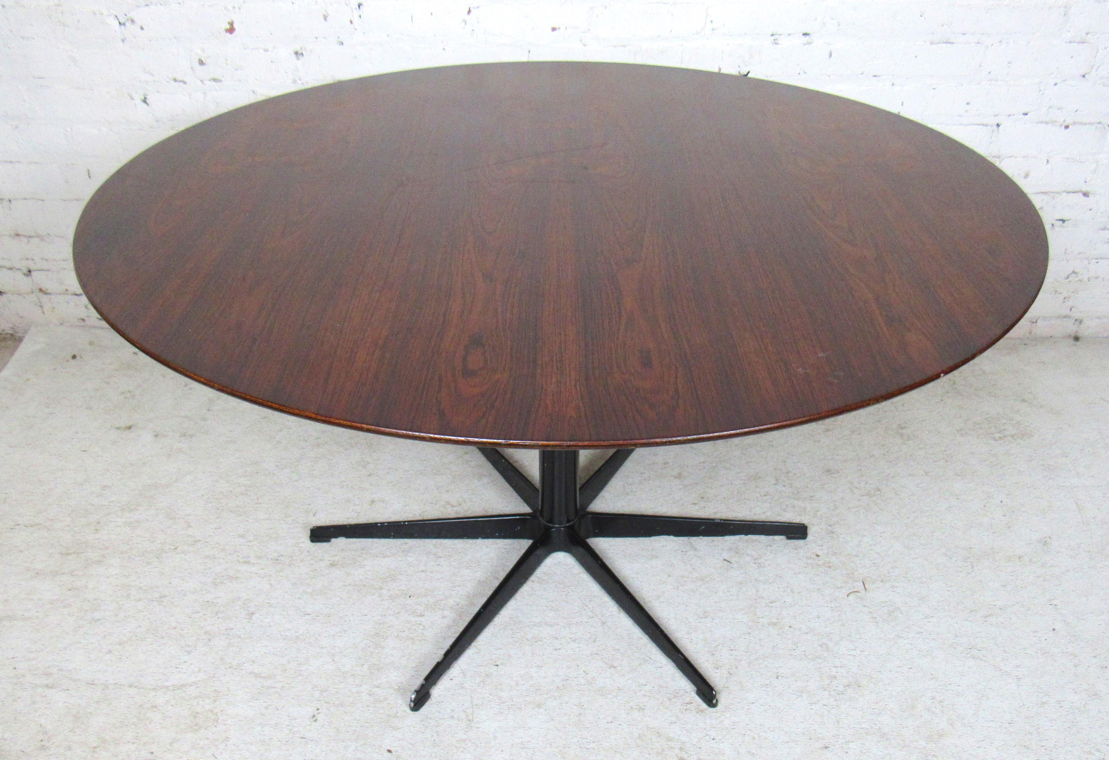 Mid-Century Modern round rosewood dining table with black metal star base.
(Please confirm item location - NY or NJ - with dealer).
   