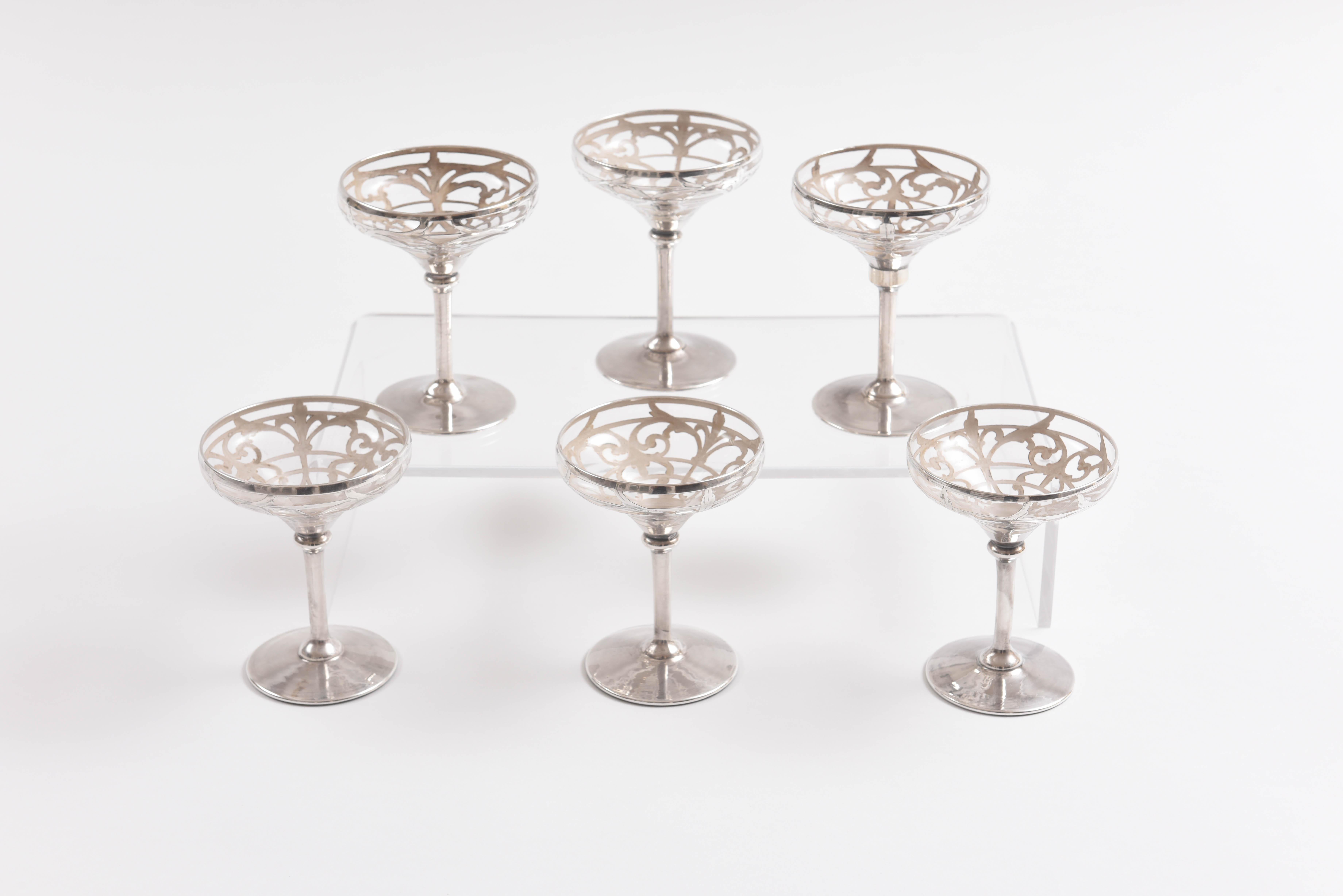 A fine set of champagne glasses that feature hand chased sterling silver on blown glass. A perfect size for sipping and also perhaps for intermezzo or sorbet. These are in Fine antique condition and will mix and match nicely in with all your fine