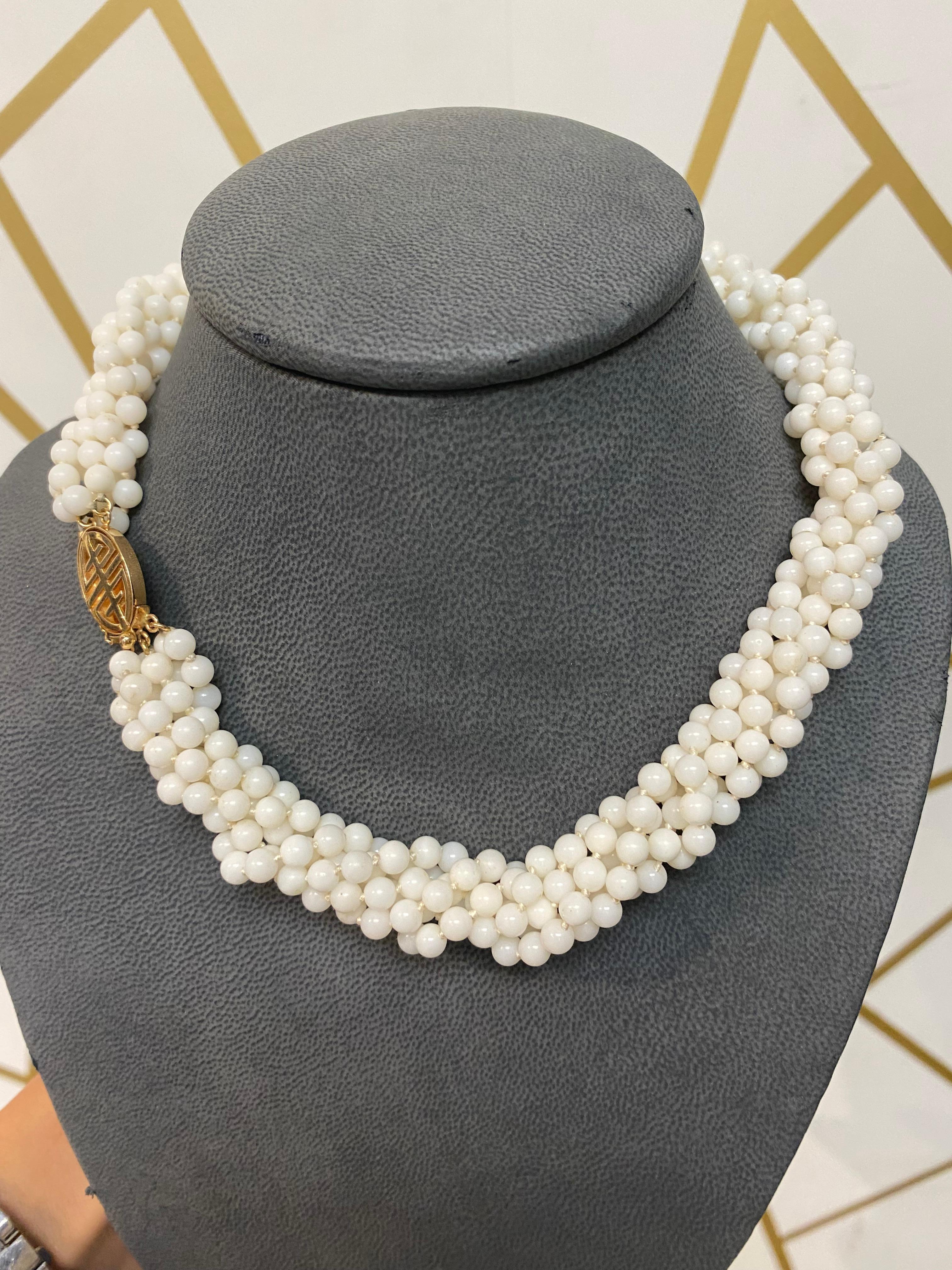 Six Strand White Coral Bead Necklace. A necklace featuring six strands of small white coral beads with a 14 karat yellow gold clasp.

Measurements: 18