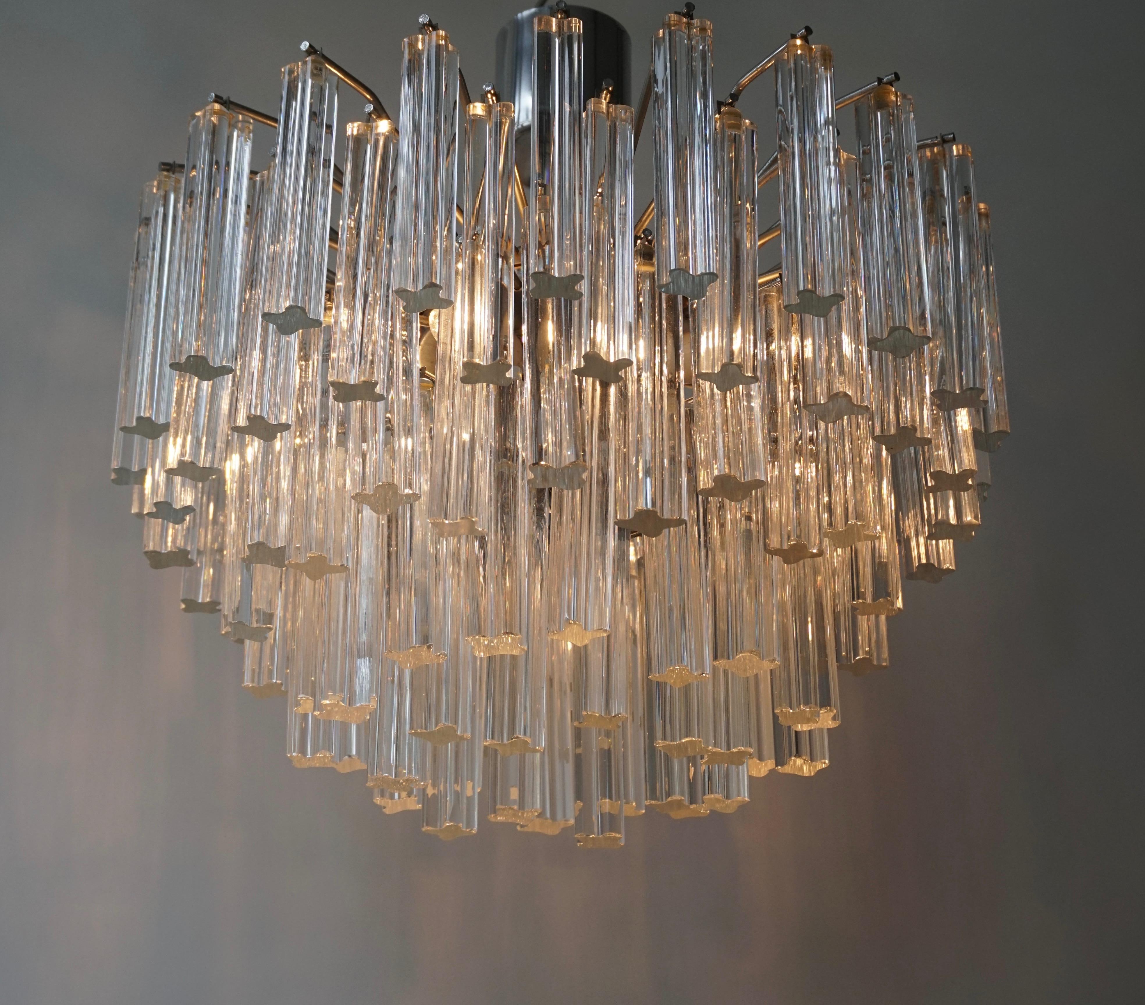 A very glamorous chandelier made up of graduating tiers of approximately 100 triangular clear glass crystals and with four light sources taking medium base bulbs. Measures:
Diameter 47 cm.
Height 48 cm.
   