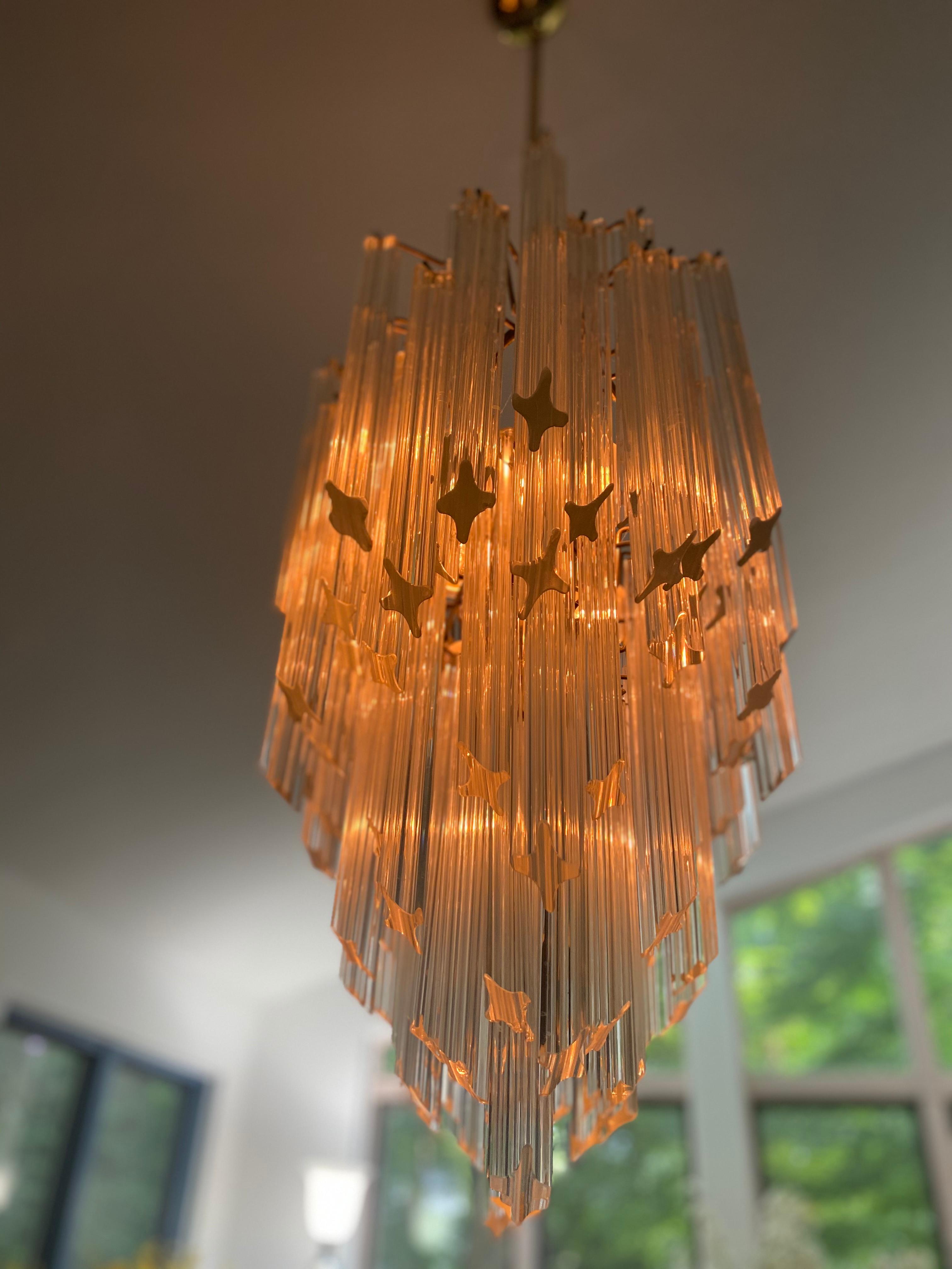 This superb Murano glass chandelier comes with 120 transparent quadriedri prisms on gold frame and 6 light bulbs.
A circa 1960s six-tier oval chandelier, suspended from a metal rod. Wiring and sockets to US standard. Very good vintage condition,