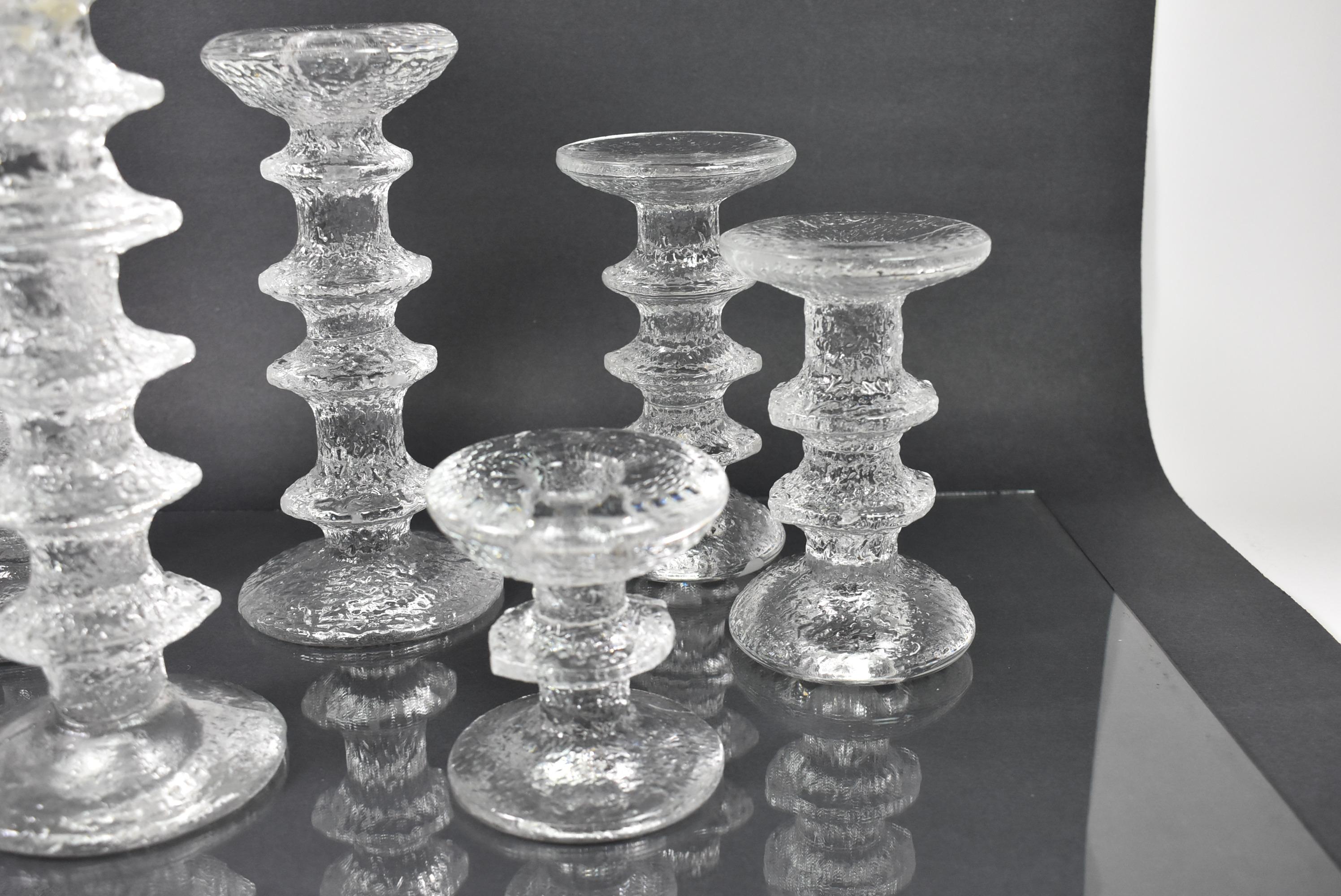 Six graduated size glass candlesticks by Timo Sarpaneva 1926-2006. Part of the Littala Festivo Collection. Sizes range from 2.5