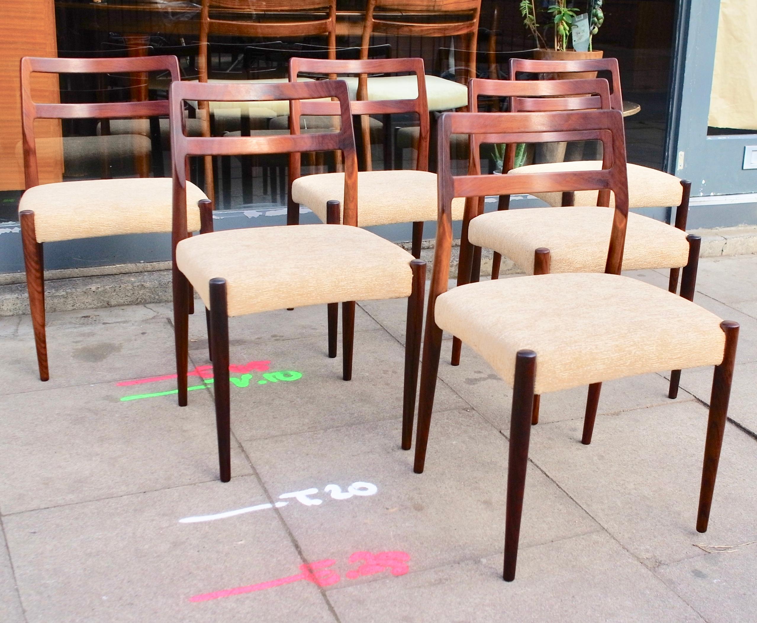 A very stylish, elegant and rare set of six 1960s Danish dining chairs, designed by Johannes Andersen and produced by Uldum Mobelfabrik. Created in solid Rosewood, and recovered in a textured taupe coloured, quality textile. These classic and high