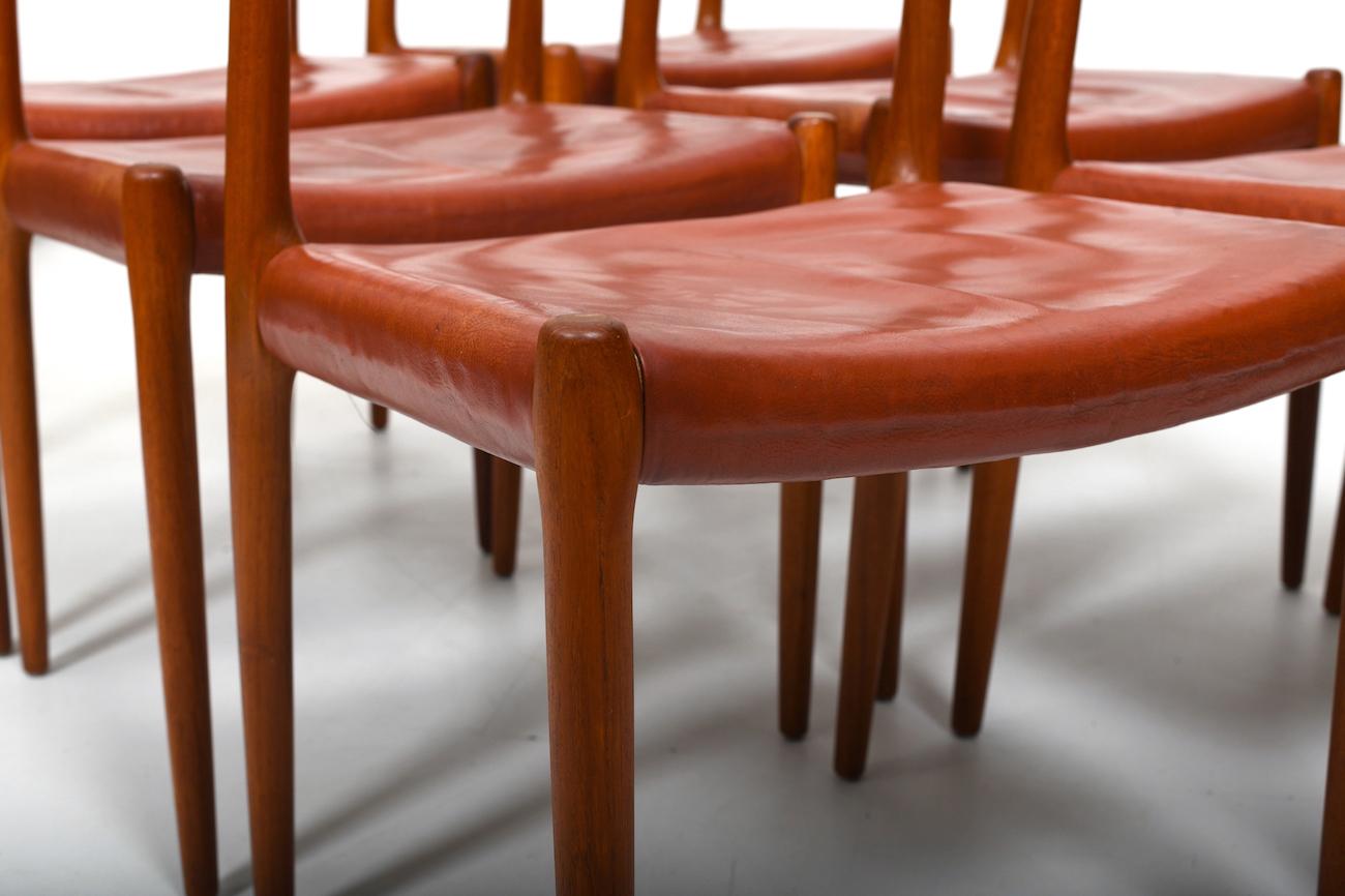 Six beautiful old Niels O. Møller chairs in solid teak and patinated „Indian Red“ leather. Model no. 79. Produced in 1960s by J.L. Møller‘s Møbelfabrik. Wood cleaned and oiled. Old Arne Sørensen leather only waxed.