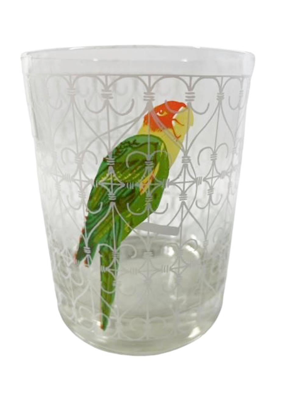 Set of six vintage rocks glasses by Cera Glassware decorated with a colorful parrot in a white scrollwork cage on clear glass.