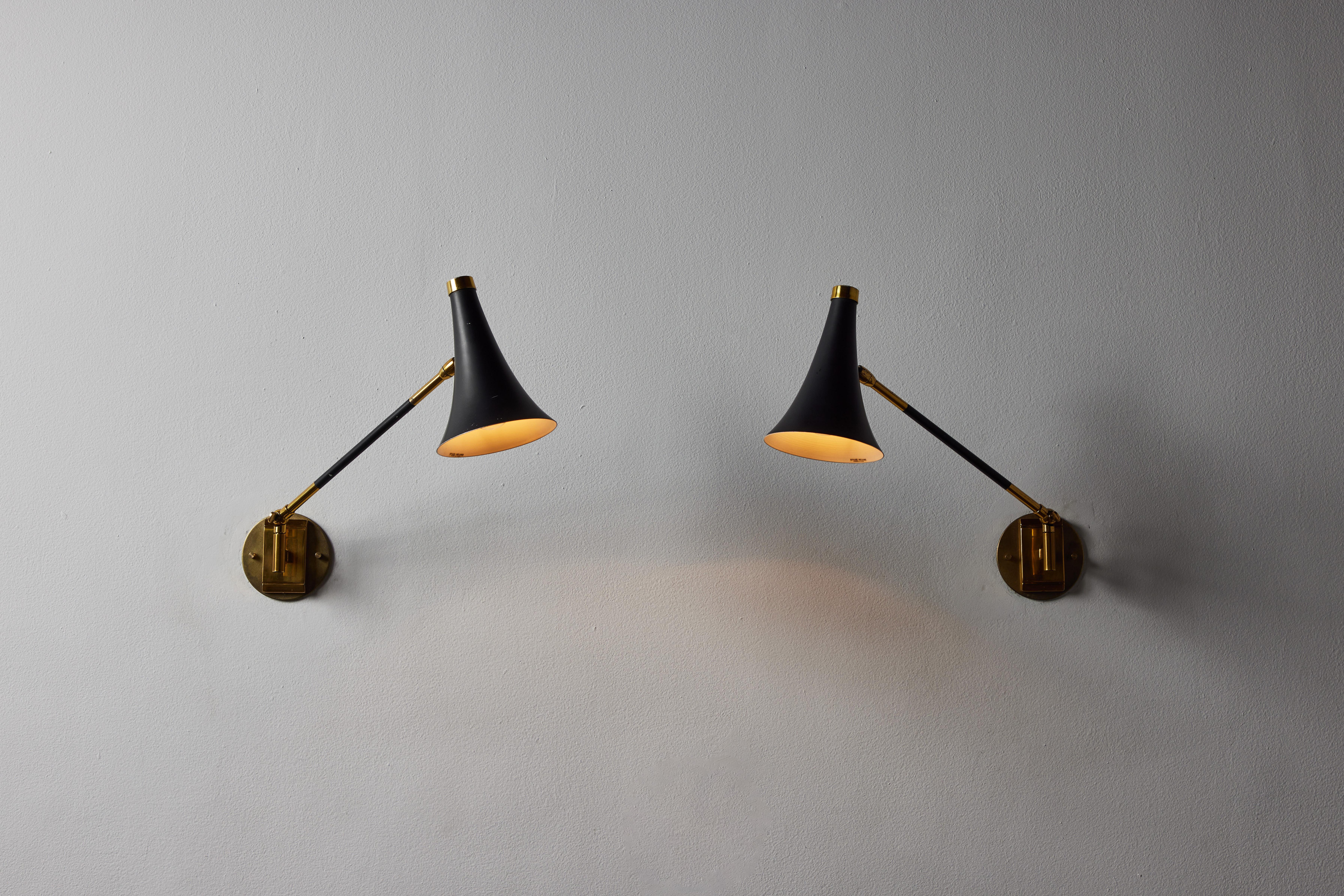 Two wall lights by Stilux. Manufactured in Italy, circa 1950s. Enameled metal, brass. Custom brass backplate. Wired for U.S. standards. Shades and arms are adjustable. We recommend one E14 European candelabra per sconce. Bulbs provided as a one time