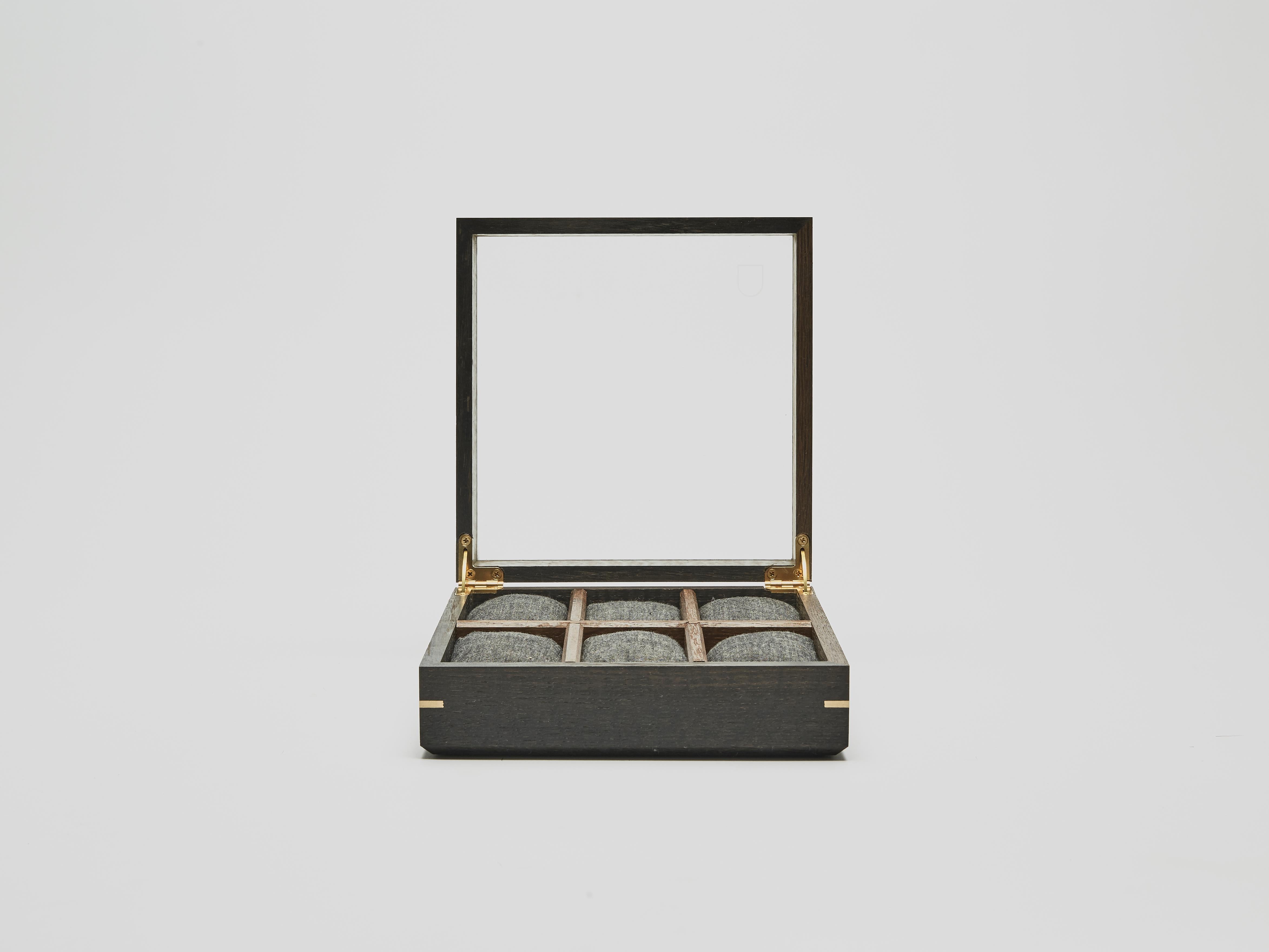 Collection Nr3, six watch box made from hardened glass and a solid bog-oak wood frame. Detailed with brass finger joints and hinges. Each product houses, three, six or ten watches at a time. They have plump cotton pillows to hold your watch