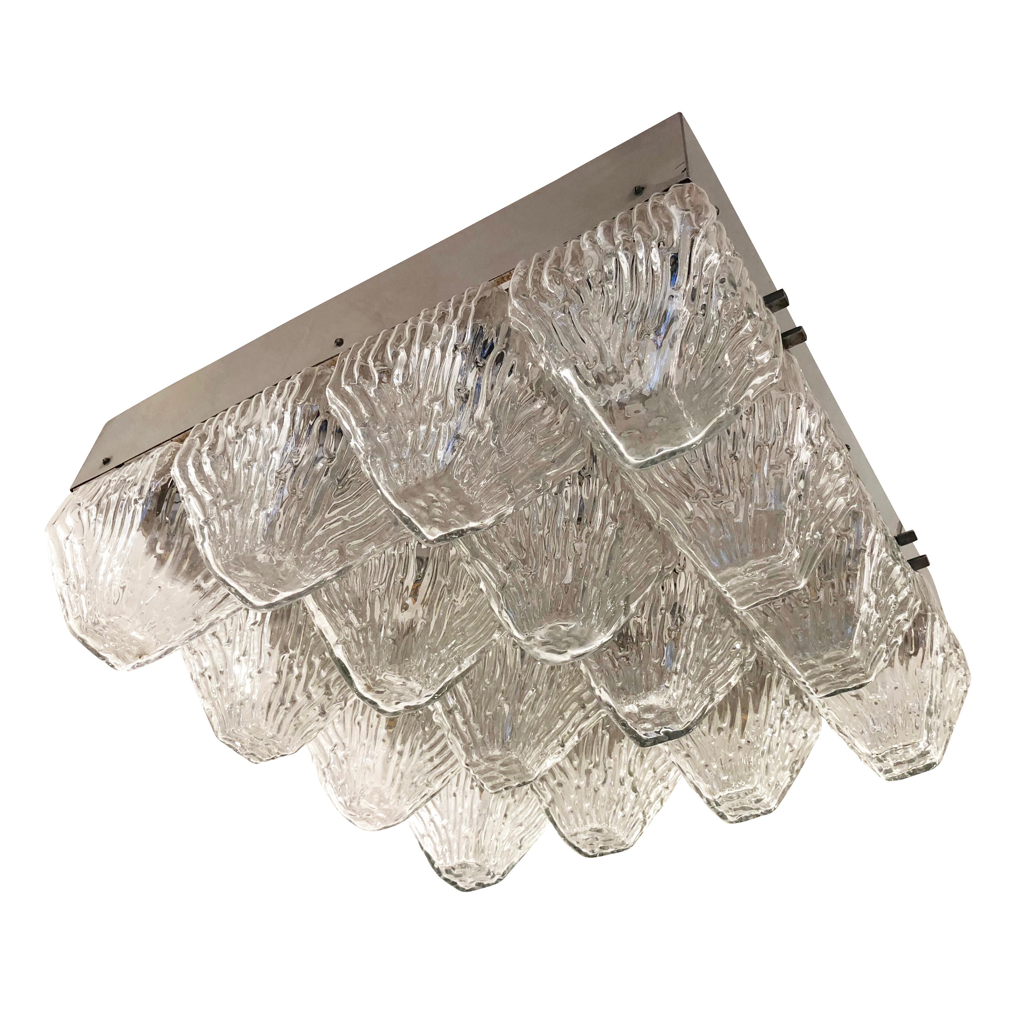 Large midcentury fixture with sixteen textured “pyramid” shaped glasses. Each glass hides one candelabra socket providing an abundant amount of light. Frame is nickel. Originally intended to be hung from two or four points, it can be modified to be