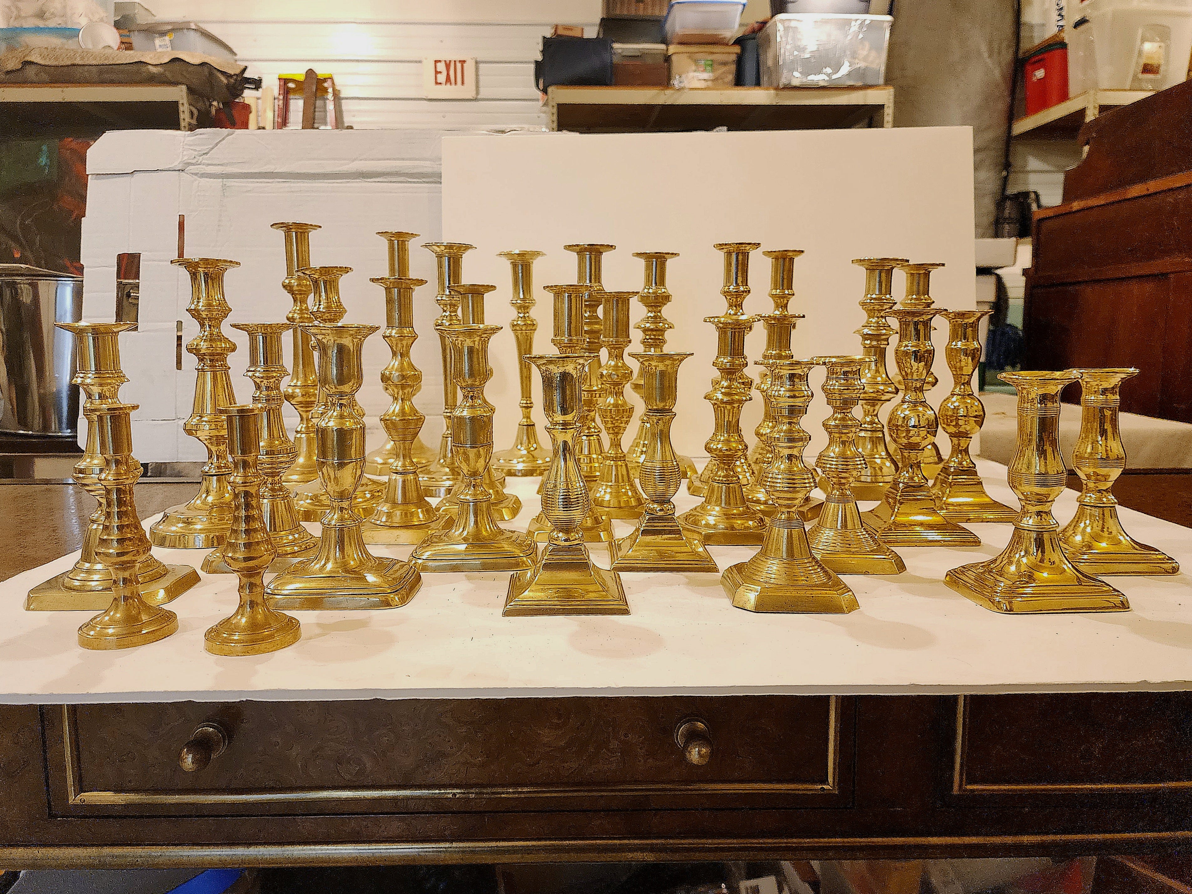 A large collection of Georgian brass antique taper or candlesticks including 32 sticks making 16 pairs. The collector used them to lean a place card on. 
A dinner party table set with 32 candlesticks with flickering tapers must be an enchanting