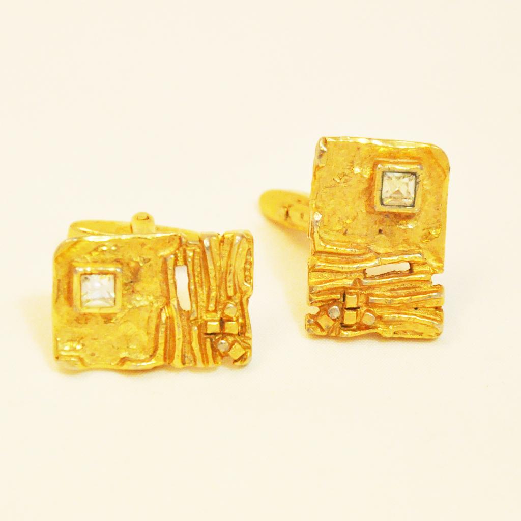 Sixties Fancy Cufflinks

gold-coloured, rectangular cufflinks in nugget look with transparent gemstone.

Classic push-through closure, also suitable for double cuffs.

around 1965

The exciting design of this typical men's accessory is particularly