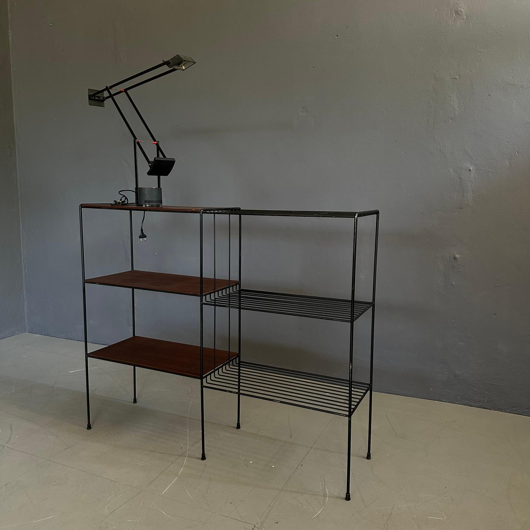 Étagère in stile anni Sessanta, realizzata con una struttura in ferro verniciato nero e ripiani in legno.
Il contrasto tra il metallo scuro e il calore del legno conferisce un carattere forte ma equilibrato, perfetto per ambienti moderni, loft o
