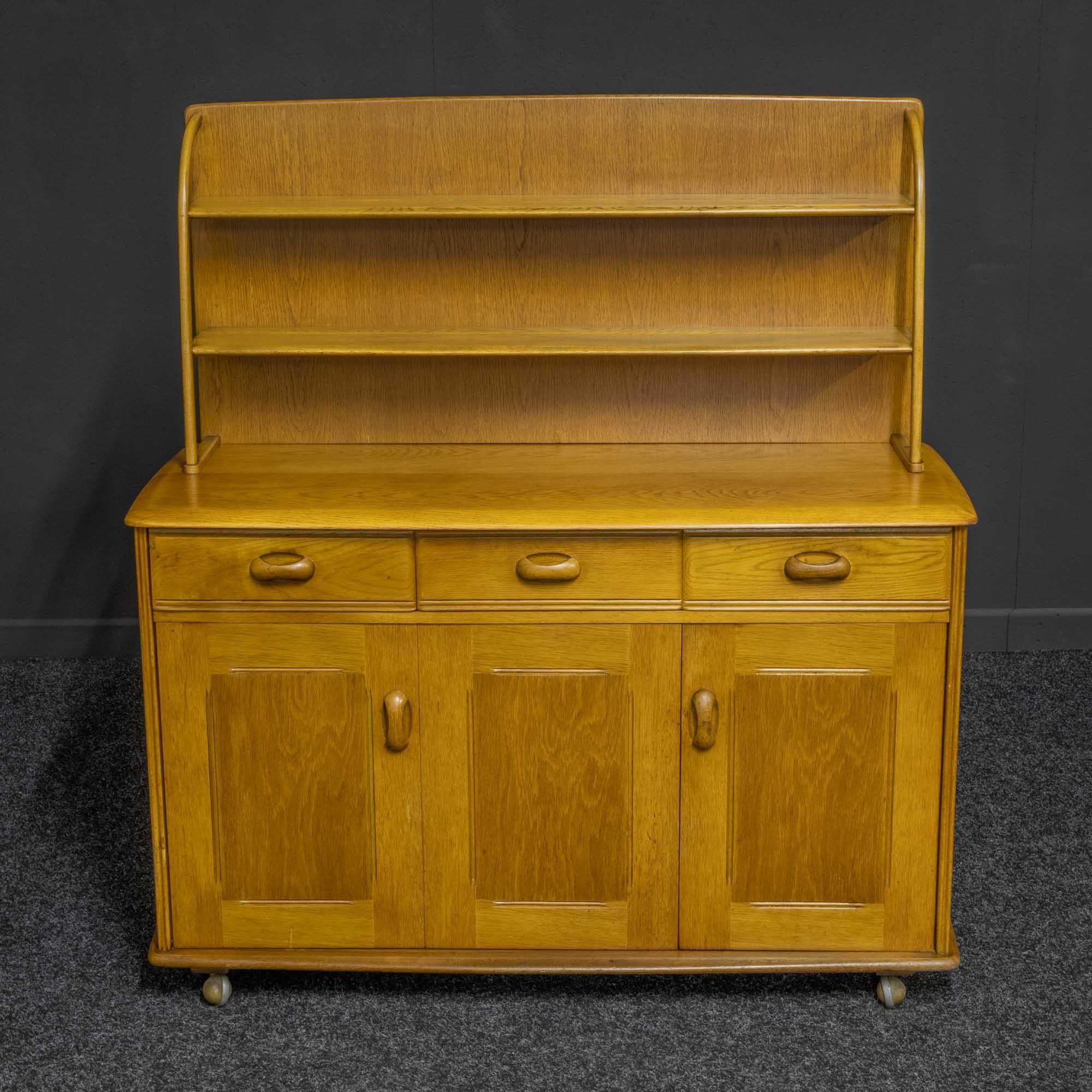 A good quality solid and veneered light oak dresser. The base has a single door and a double hinged door. The top is solid oak as are the two shelves above. The top itself is detachable by taking out two small screws and leaves two small marks on