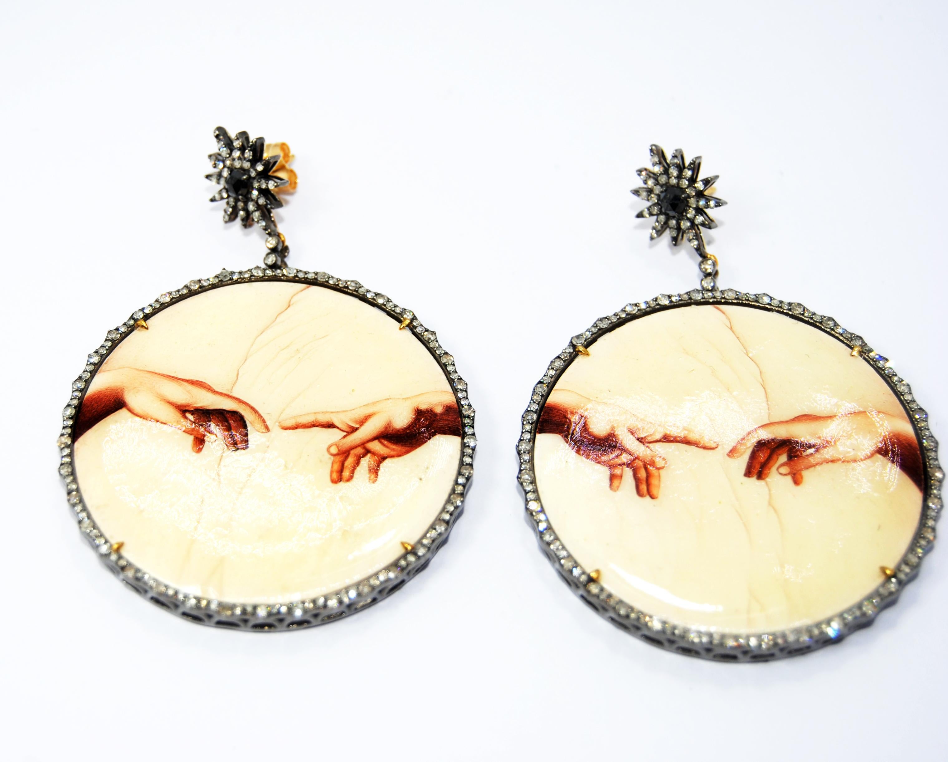 Irama Pradera is a Young designer from Spain that searches always for the best gems and combines classic with contemporary mounting and styles. 
Sleekly crafted in 18K yellow gold, painted bakelite and silver  these talisman dangle earrings are a