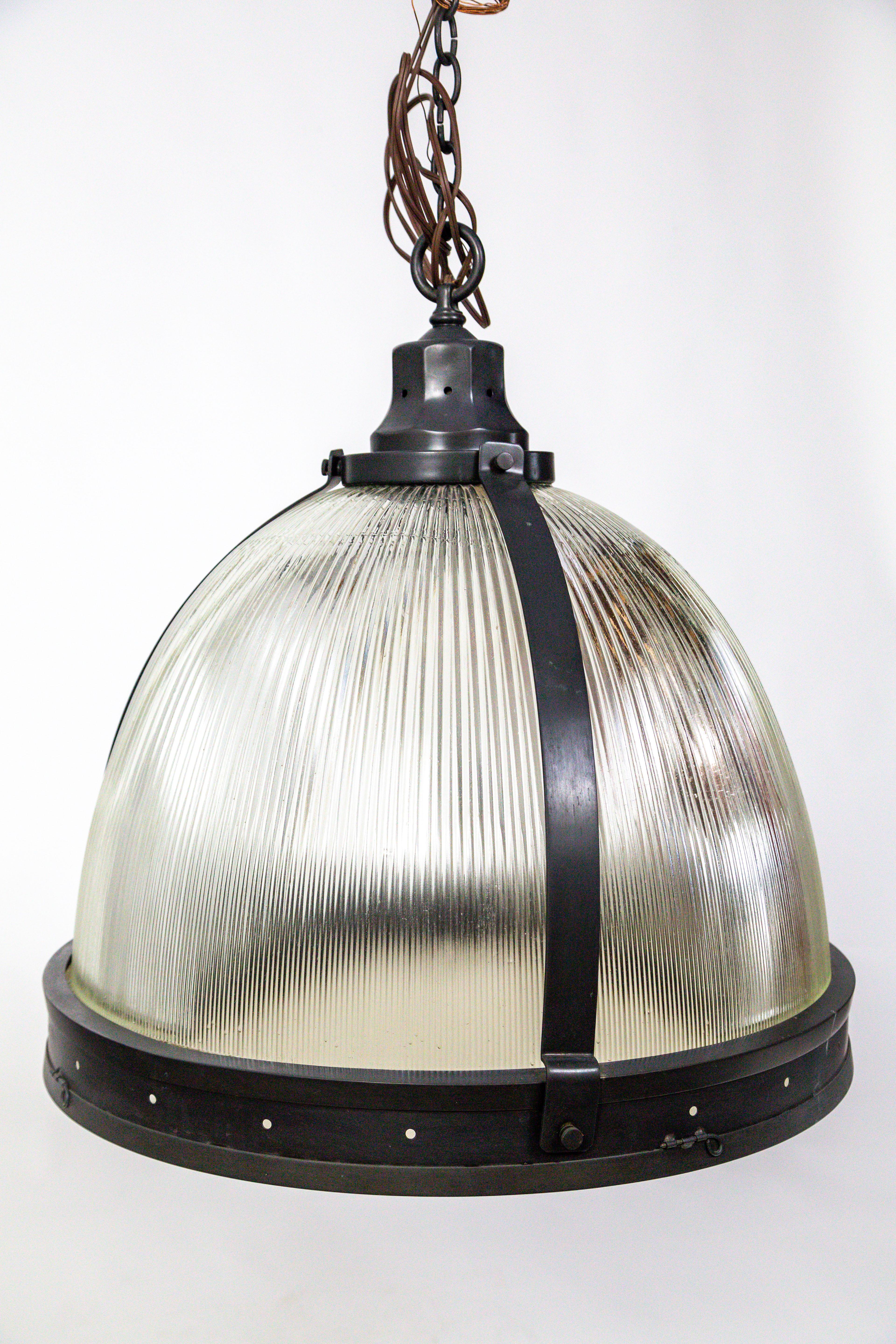 Oversized single Holophane glass pendant with attached glass diffuser. Hand rubbed bronze finish on all brass fittings.