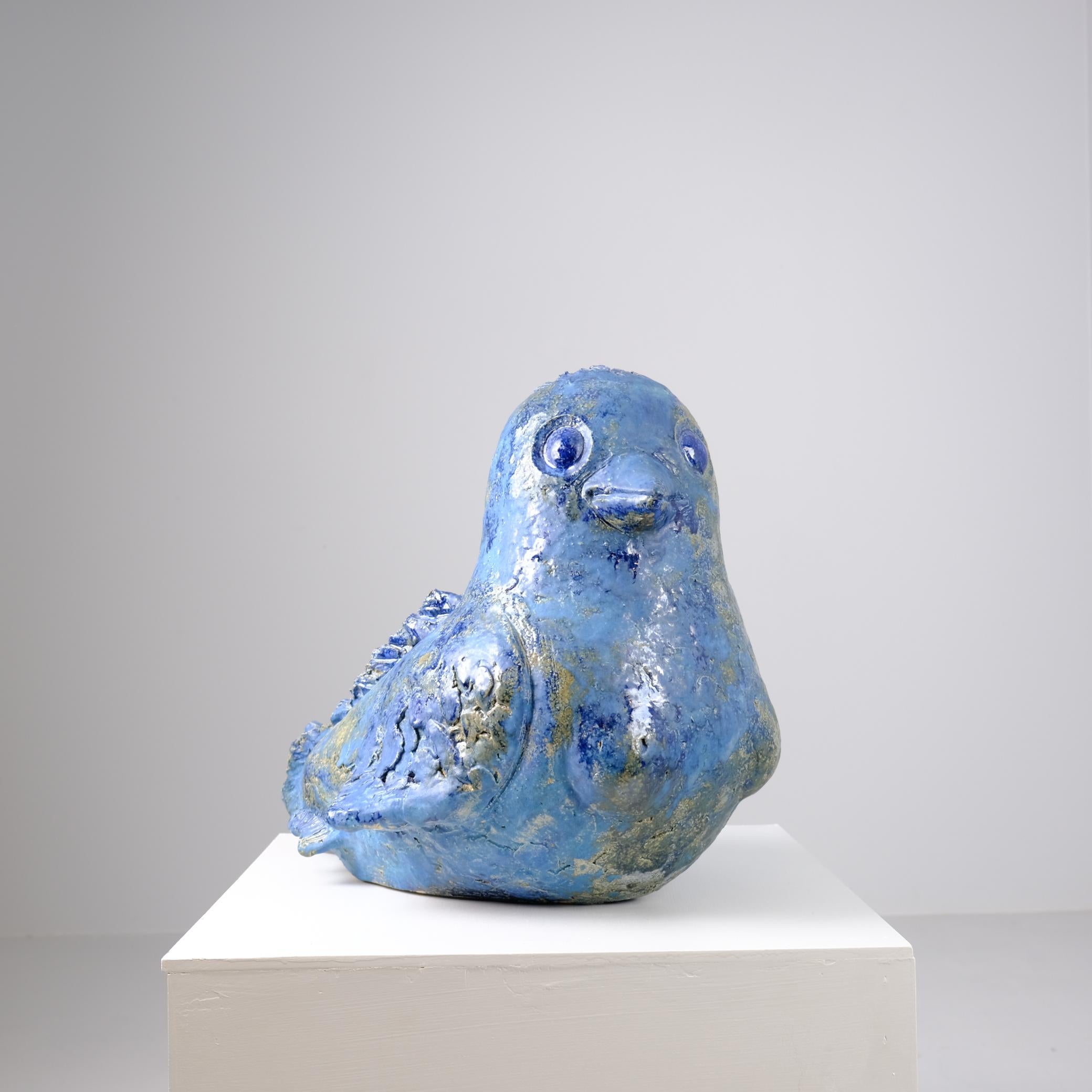 Figurine en céramique aux tons bleus profonds, Sirenes combine les traits d'un oiseau, d'un poisson, d'une sirène et d'un être humain. Le résultat est une présence sereine mais frappante, une créature qui semble s'être adaptée à un environnement
