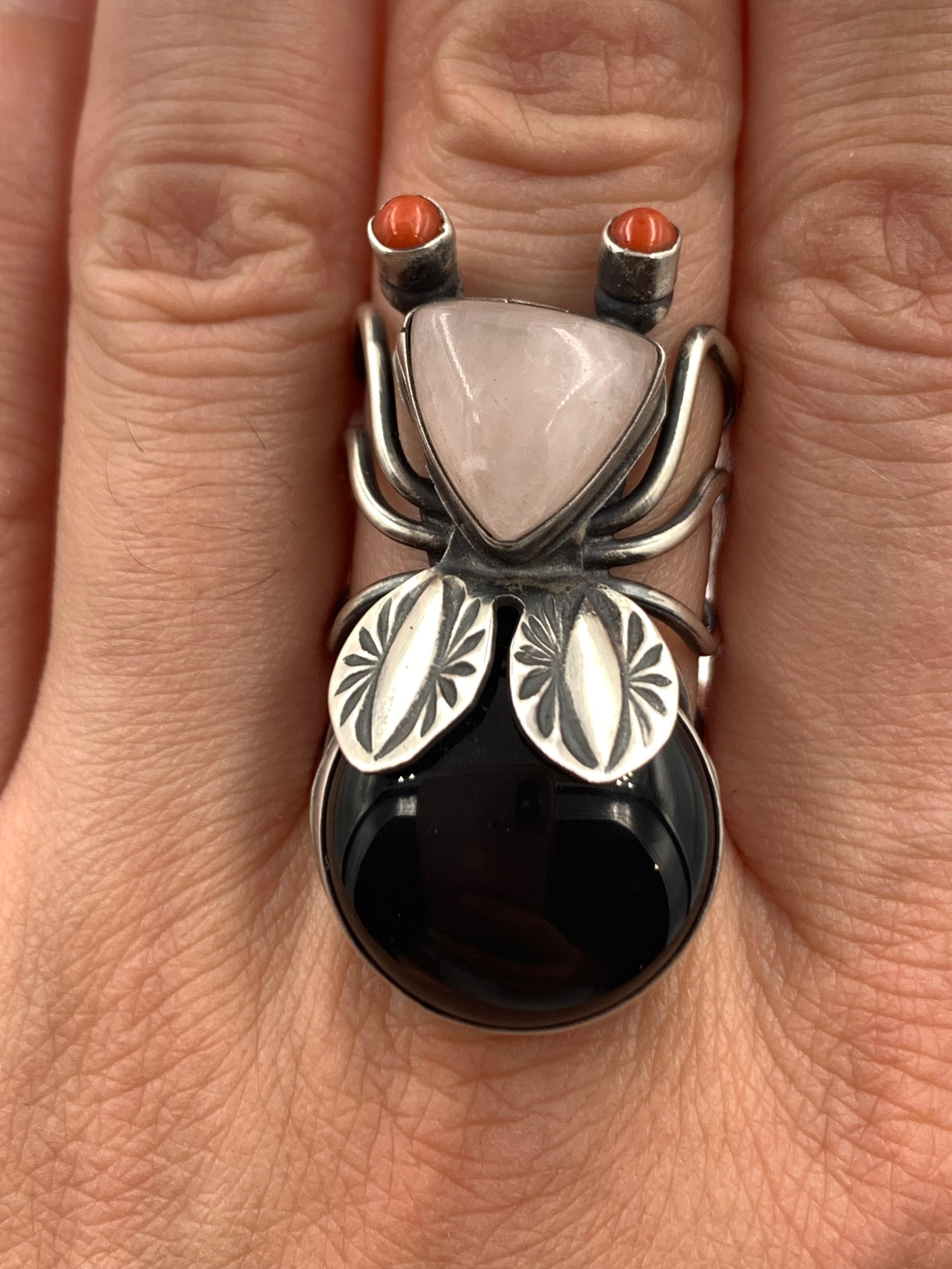 Sterlingsilberring des Navajo-Silberschmieds Herbert Ration.  Die Ringe bestehen aus einem Körper aus Hämatit, einem Kopf aus rosa Quarz und Augen aus Koralle.

Maßnahmen:  3/4” x 1 3/8” 

Größe 7

Schöpfer:
Herbert Ration ist in Crownpoint geboren