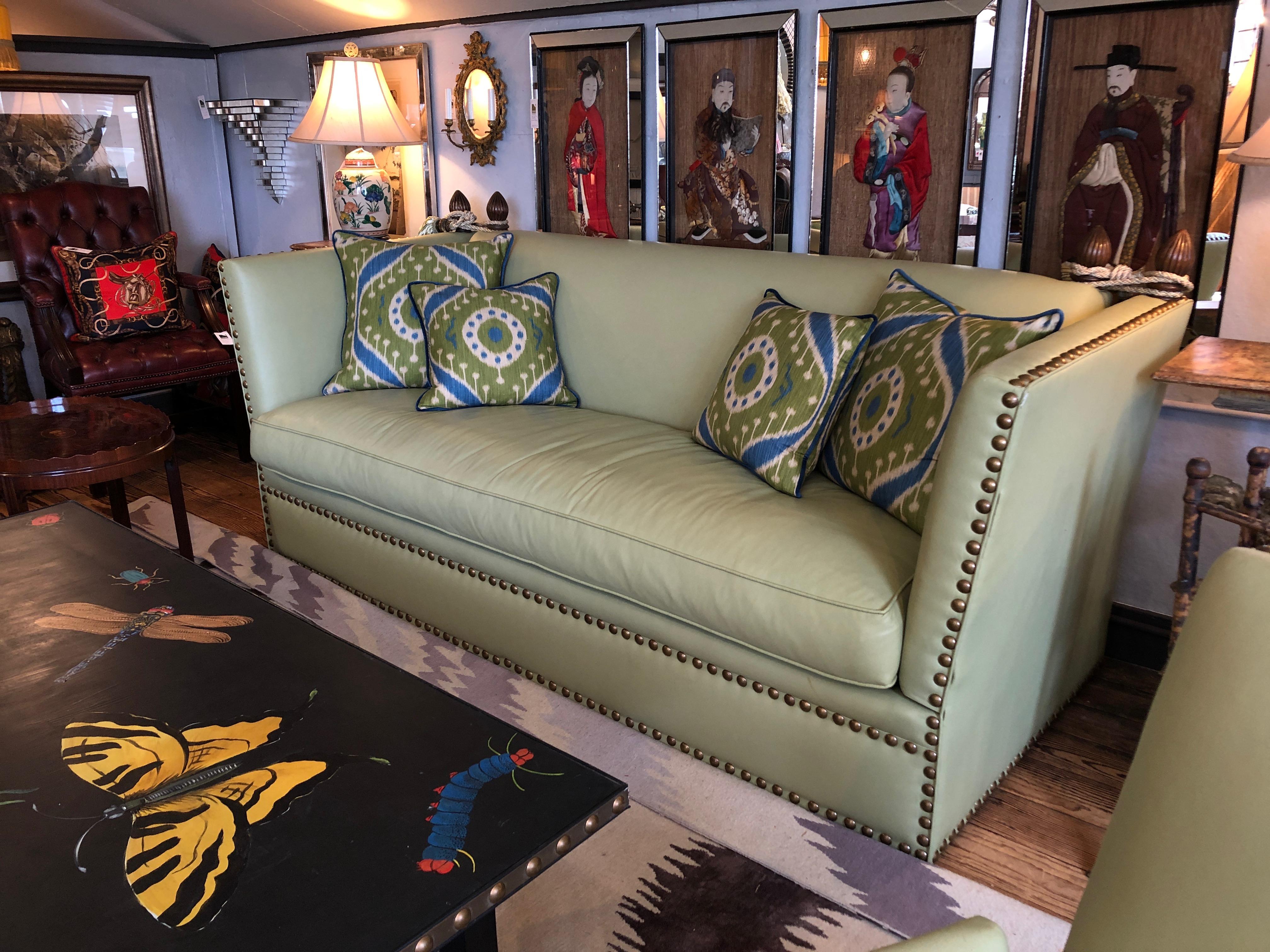A fabulously stylish version of a Classic Knole sofa having mahogany finials at the top corners with rope and tassels, in a sizzling hot soft shade of lime green leather finished with big bold brass nailheads. Coordinating Ikat inspired contemporary