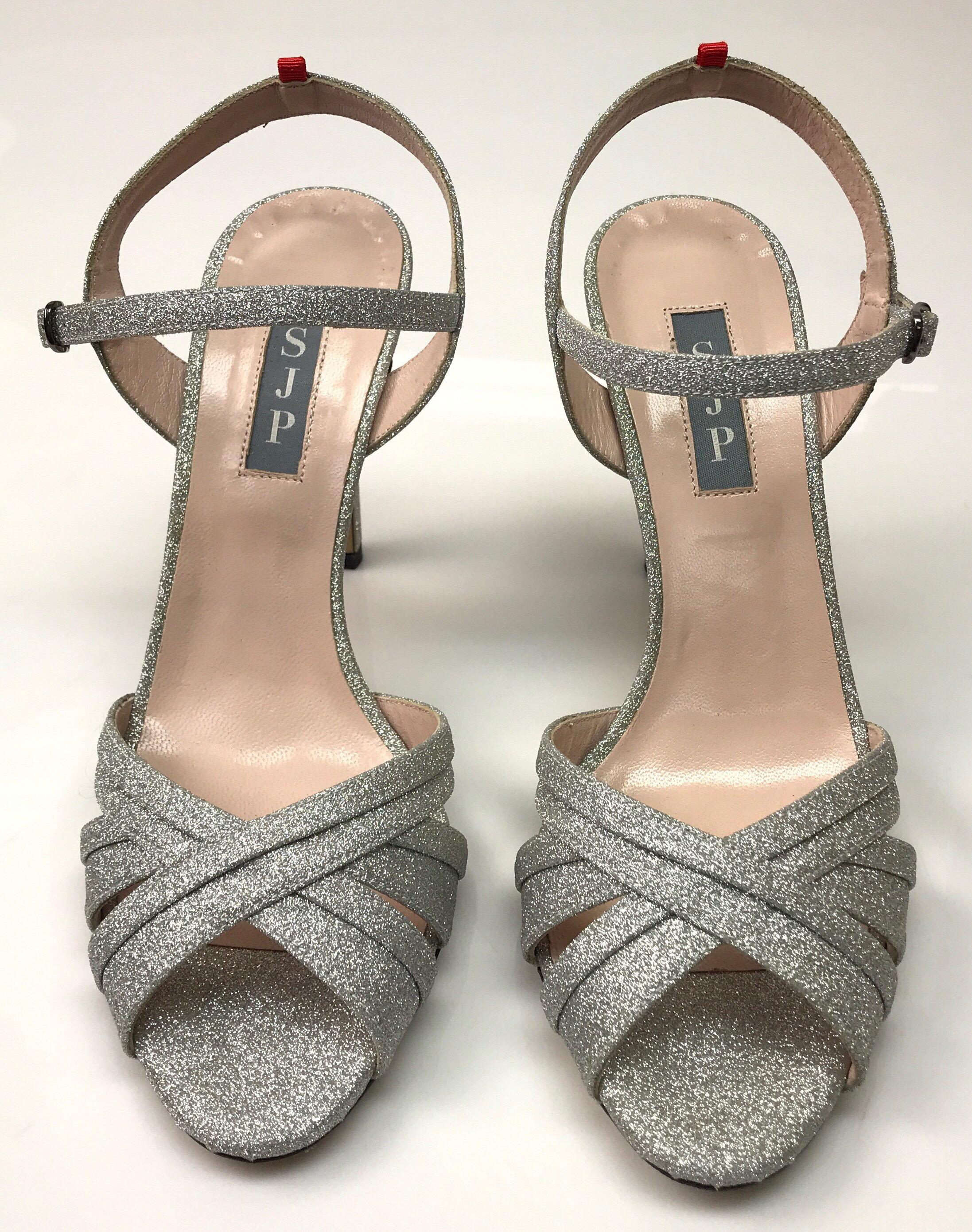 SJP Silver Glitter Ankle Strap Sandal-38.5. These amazing Sarah Jessica Parker heels are in excellent condition. They show barely any use, with small smudges on the bottoms, shown in picture. They are a silver, sparkly color and have a strappy toe